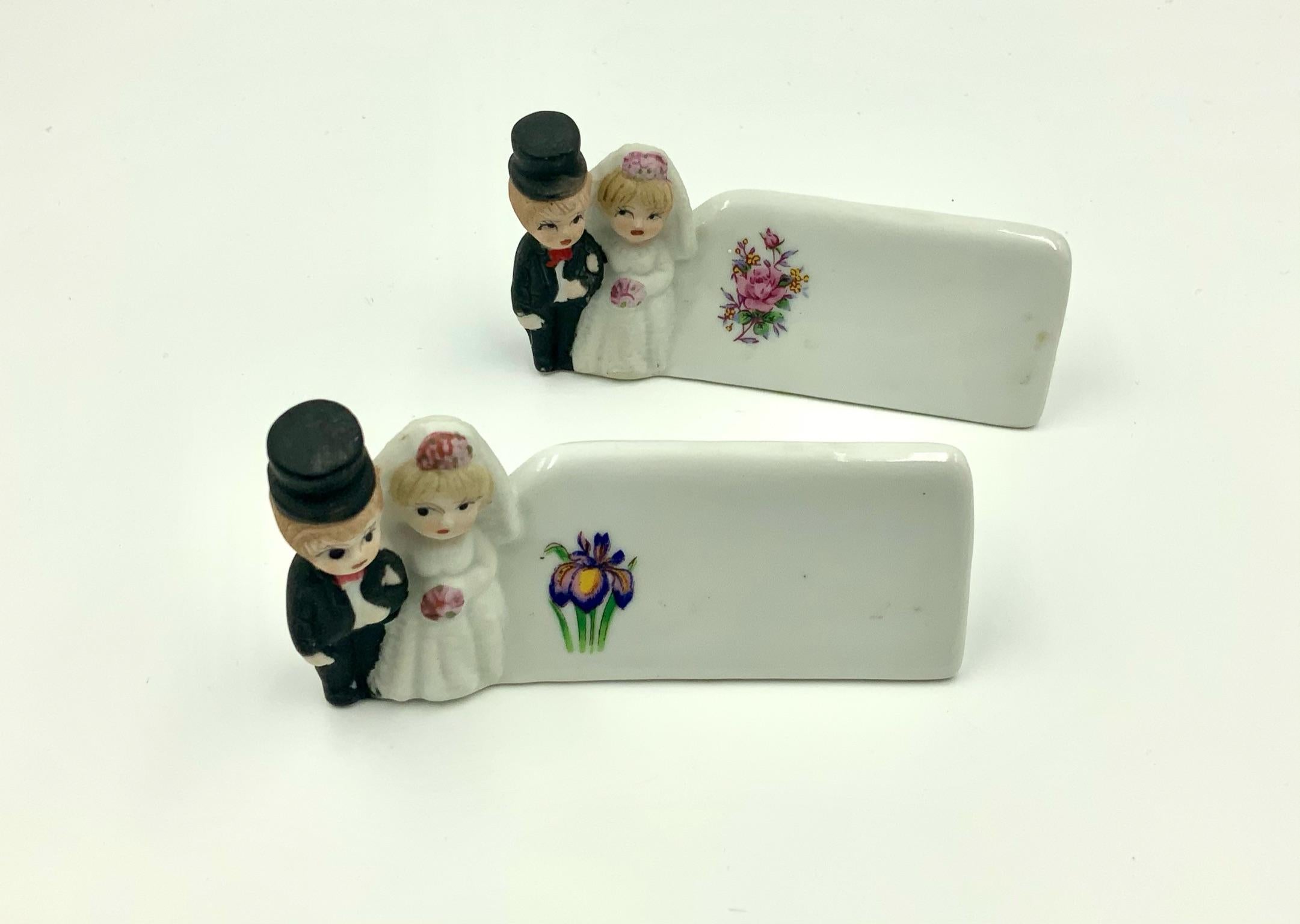Hard to find adorable hand-painted bride and groom place card holders with flower decals. I have 3 sets of 2 available. Each pair has a different flower on the name area. One of the sets has a crack on the bottom. That set is listed separately at a