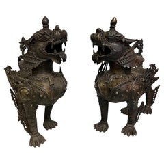 Coppia di cani da caccia o leoni delle nevi tibetani in armatura completa della metà del XX secolo, in bronzo
