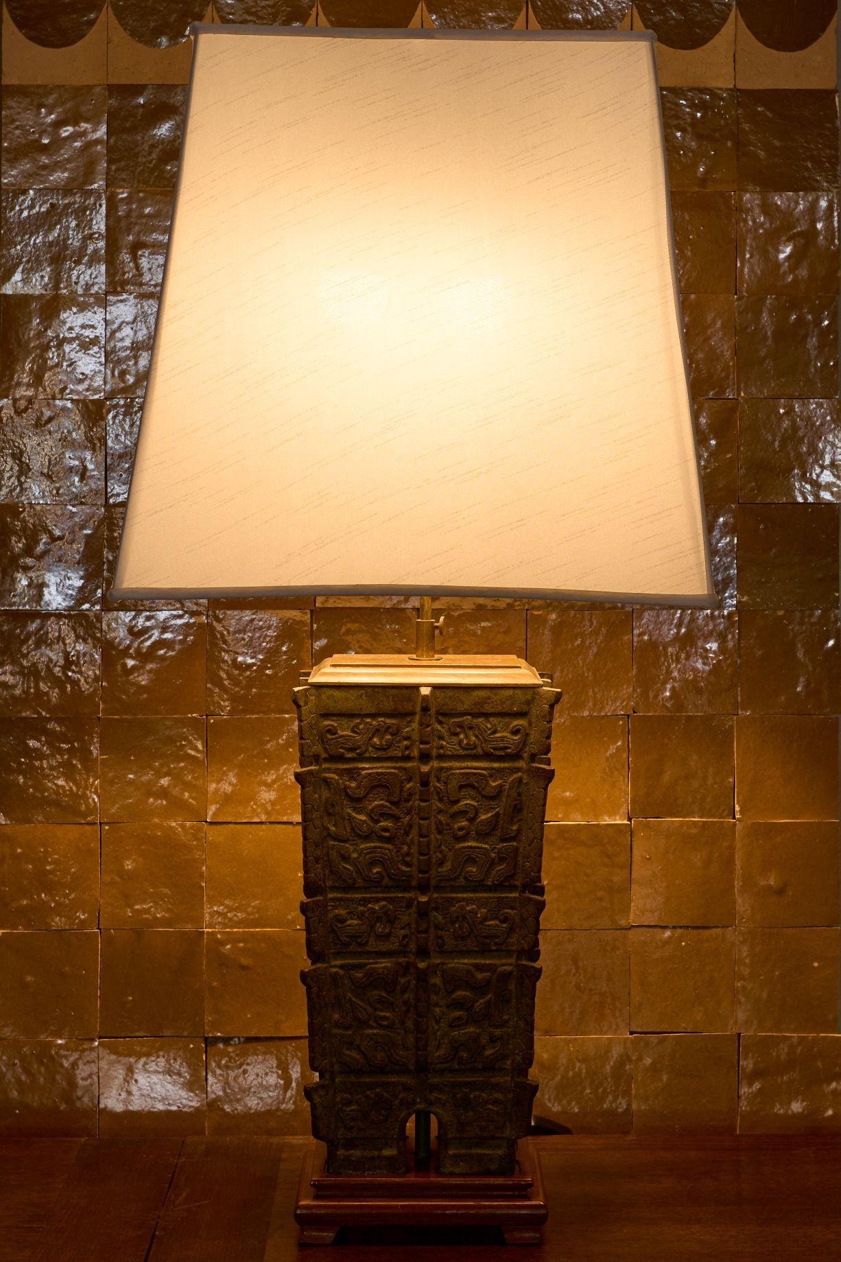 Il s'agit d'un superbe vase en bronze du 19e siècle qui a été transformé en lampe de table au milieu du 20e siècle. Le vert-de-gris est d'une couleur magnifique et se marie très bien avec la base et le plateau en bois. L'abat-jour est en soie et est