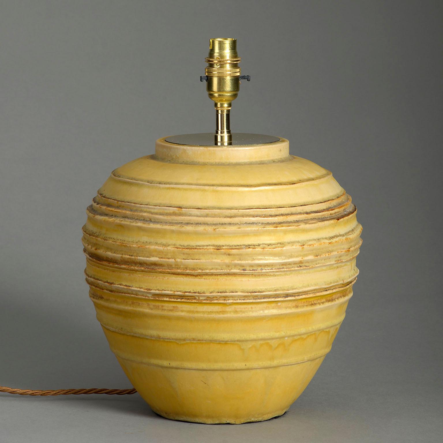 A mid-twentieth century studio pottery vase, the bulbous body with thrown ringlets and an ochre glaze. Now mounted as a table lamp.

Dimensions refer to ceramic elements.

Display shade not included.
