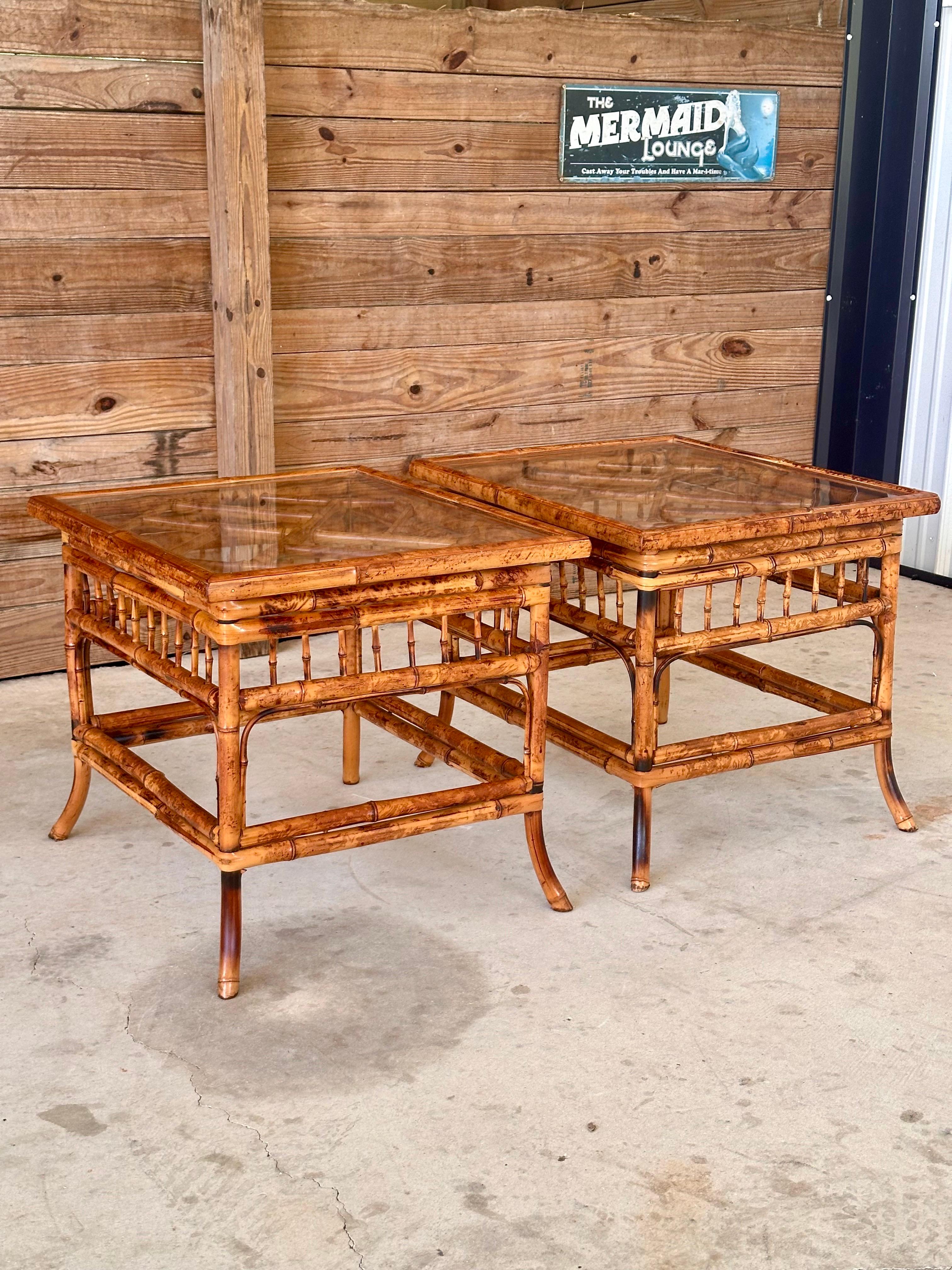 Elevate your Coastal interior decor with this exquisite pair of Vintage Burnt Bamboo Brighton Pavilion side end tables.
Featuring a classic Chippendale design on the top, these tables showcase intricate craftsmanship and timeless elegance.
The tops