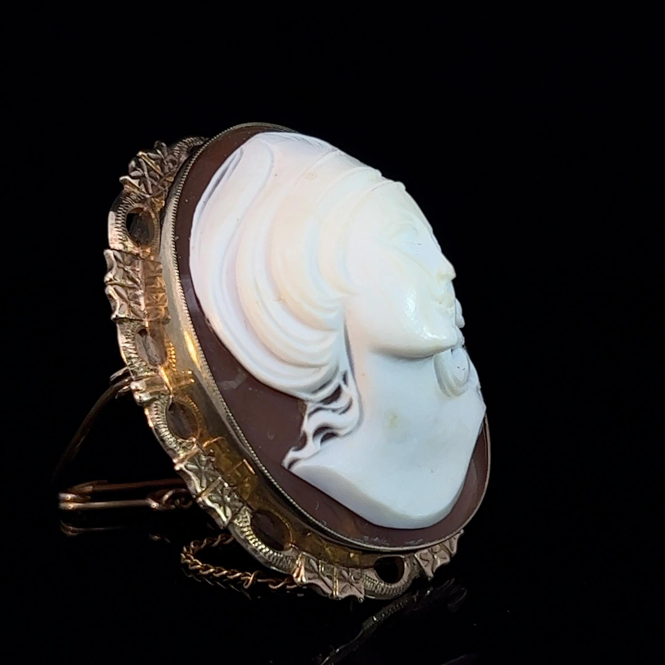 Mid 20th Century cameo brooch. This shell carved cameo of a woman in high relief is beautiful. Fitted with a metal pin and safety chain with pin.

Gemstone: Shell cameo (3.4cm x 2.7cm)
Metal: 9k yellow gold
Weight: 15.09 grams
Measurements: Length