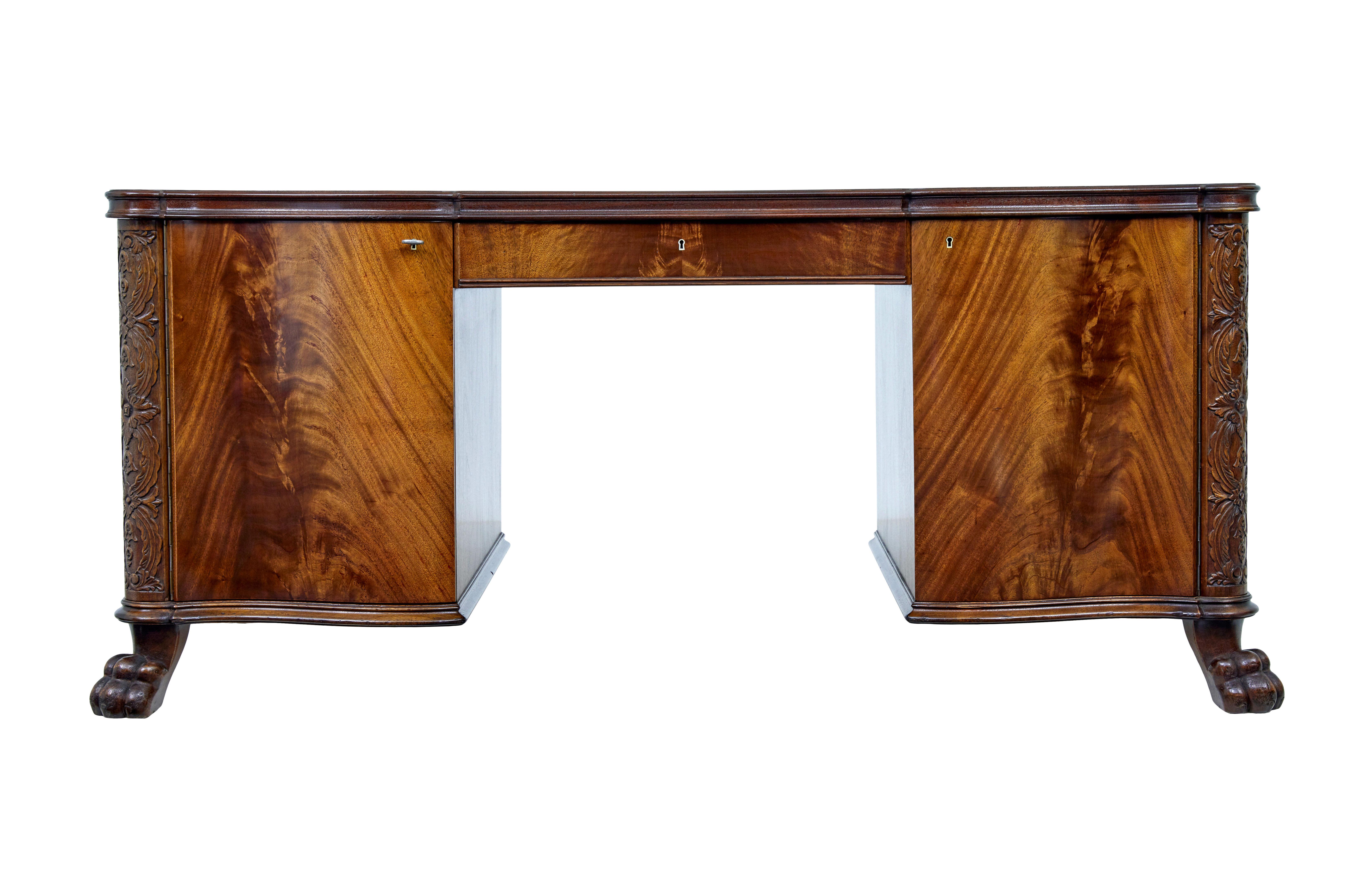 Mid 20th century carved mahogany swedish desk circa 1947.

We are pleased to offer this superb quality desk, which is stamped proving that it was part of the swedish royal family's inventory and a makers date of 1947.

Shaped top which matched flame
