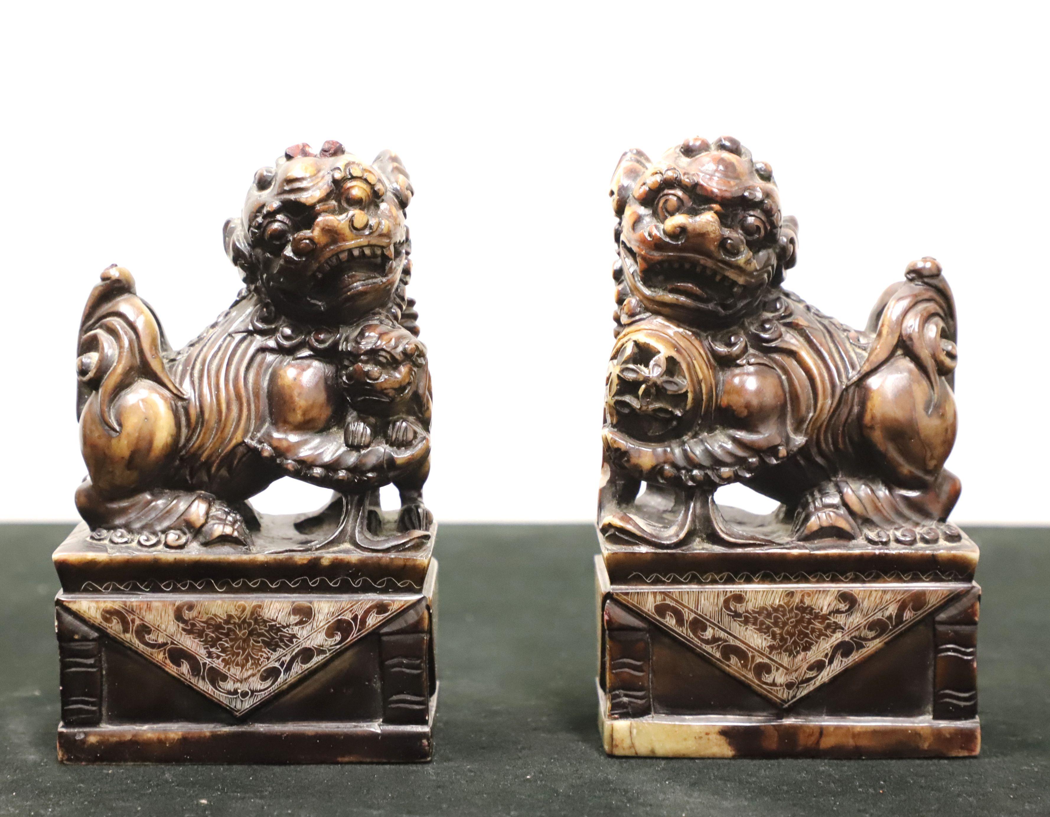 A pair of Foo Dog sculptures in soapstone depicting mythical lion-like animals that are protectors, 
