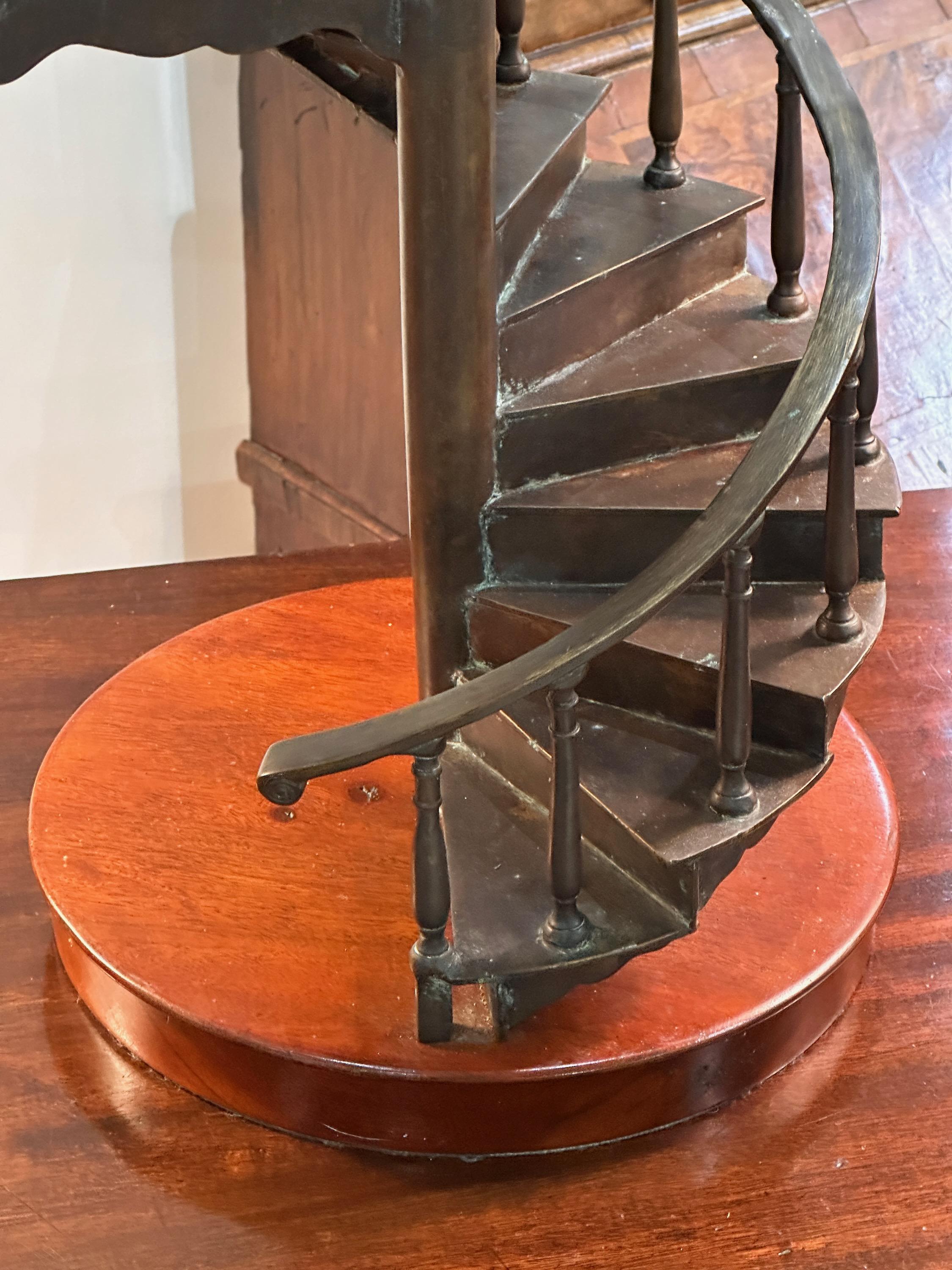 A mid-20th C. cast bronze architectural model of a spiral staircase rested on a mahogany base.