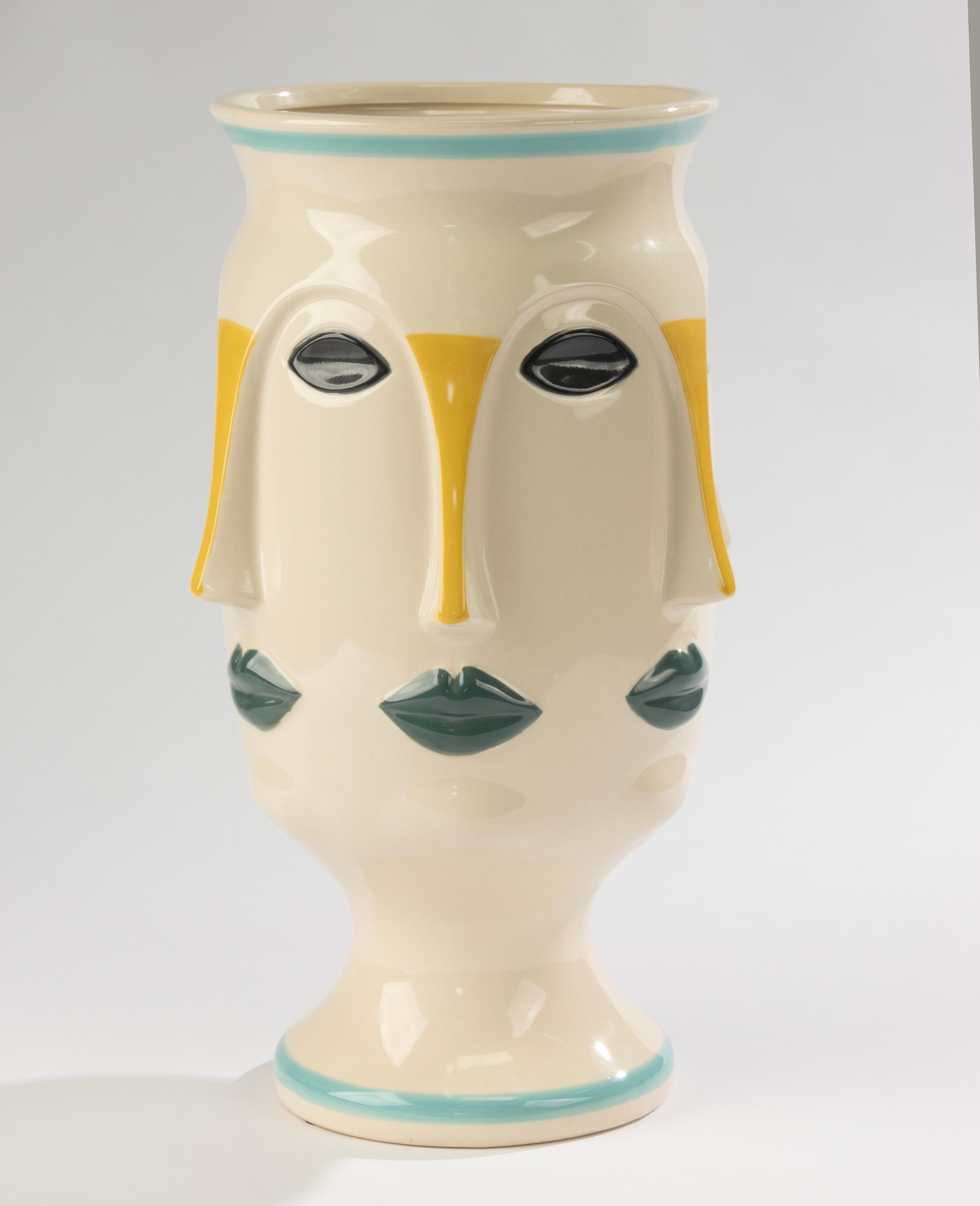 Grand vase en céramique de Vallauris, France, datant des années 1950-1960.
Cette pièce décorée à la main présente un design artistique de style cubiste avec de multiples visages stylisés en relief, accentués par des détails peints en vert, jaune et
