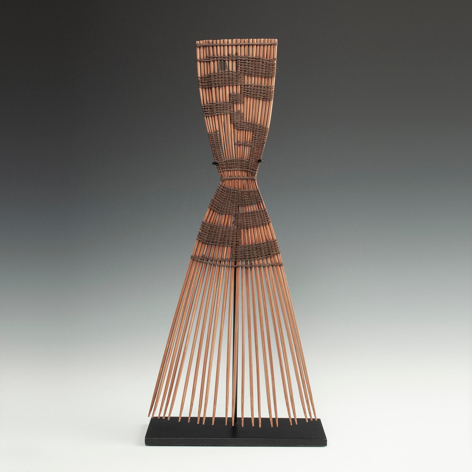 Ceremonial comb, Luba People, Zaire, D. R. Congo

Made of palm leaf midribs, this large, graphic comb has a pinched waist and is held together with finely wrapped wire. Presented on a custom base, it is a striking example of its type. Measures