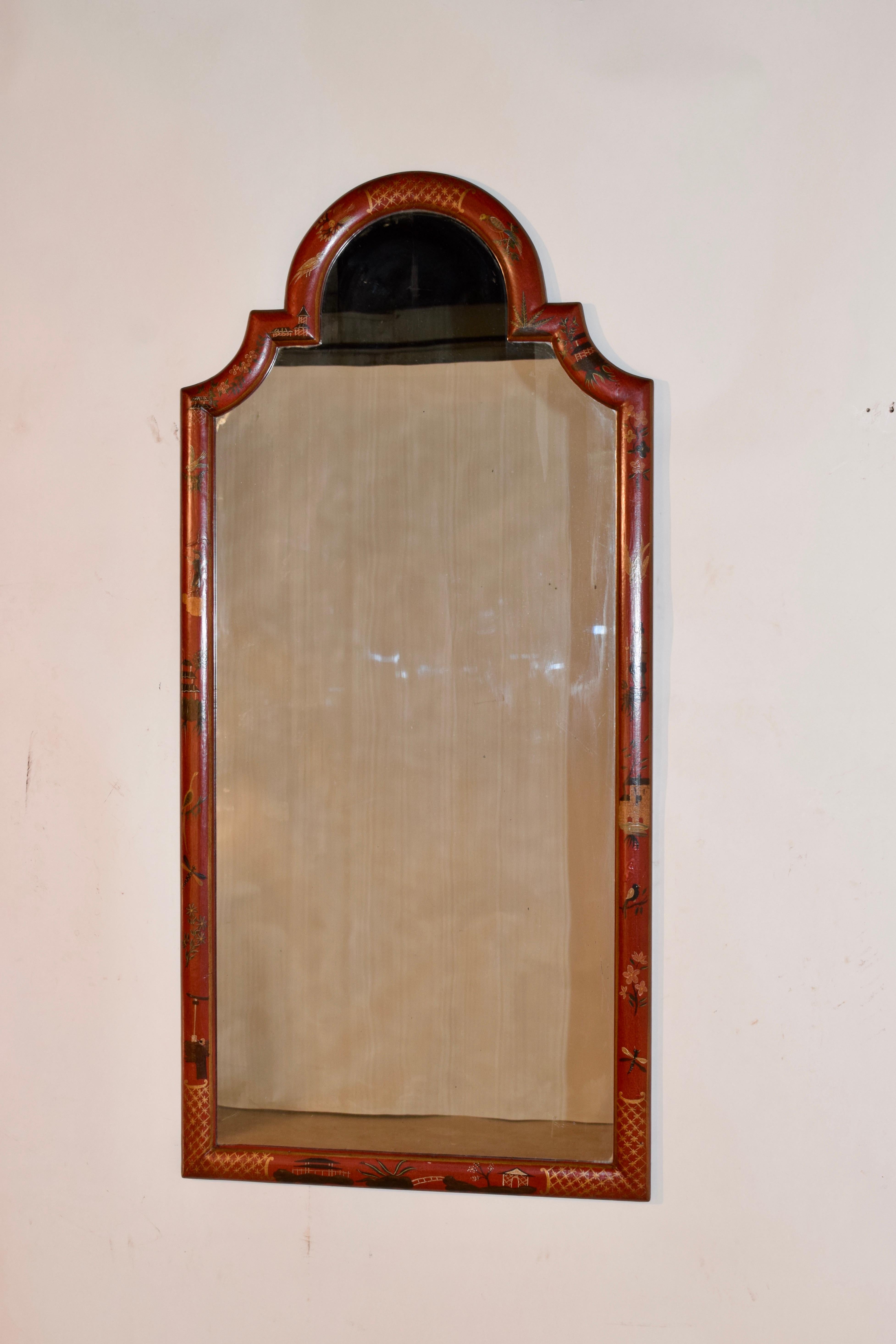 Mid-20th century Chippendale style mirror in a wonderful brick red color with chinoiserie style painting in gold on the frame. Marked Chapman on the back.