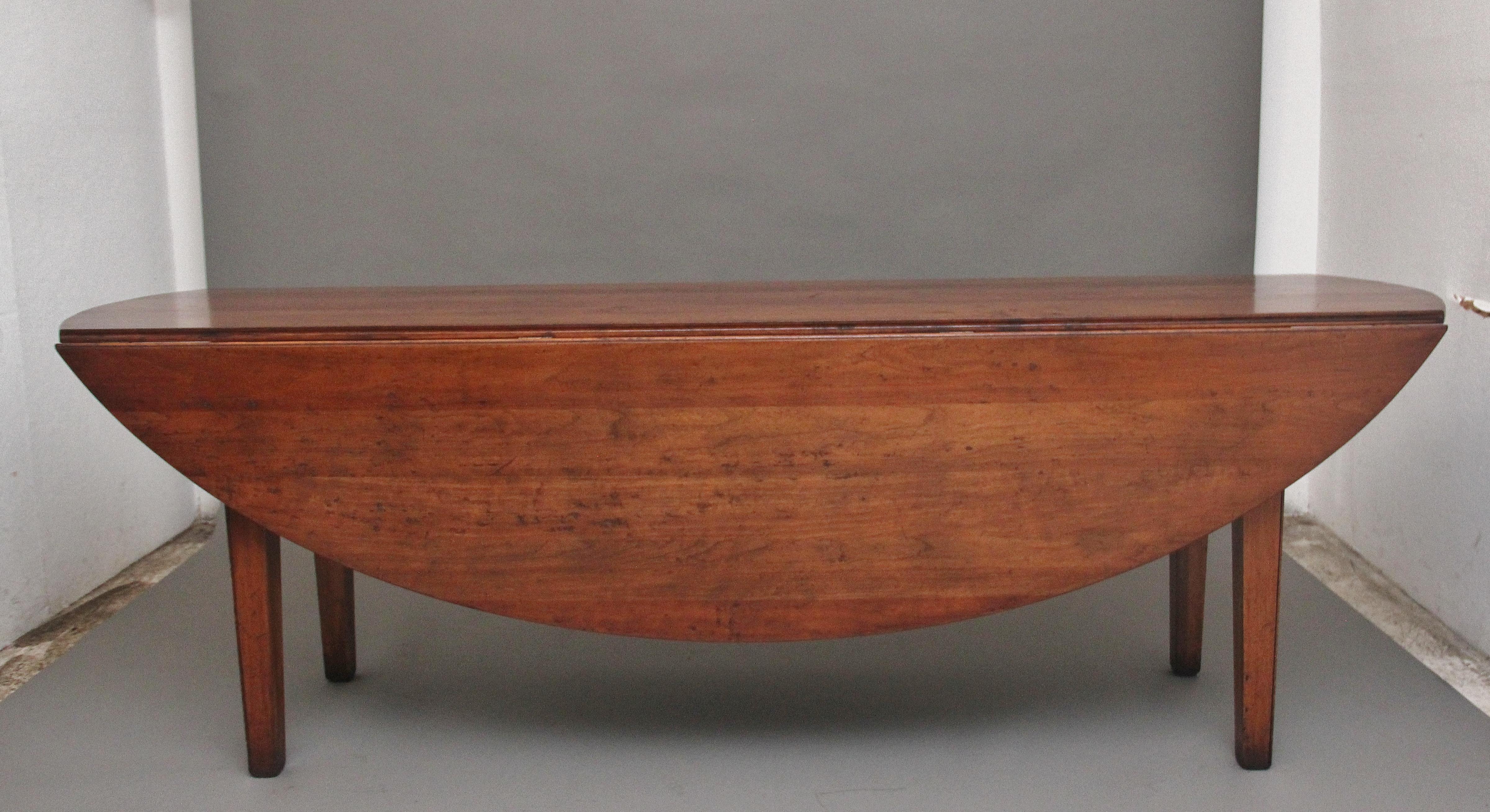 Grande table de salle à manger en cerisier du milieu du 20e siècle, avec un magnifique plateau sculpté, de forme ovale une fois déployé, reposant sur des pieds carrés effilés.  En excellent état et d'une belle couleur cerise chaude et riche. 