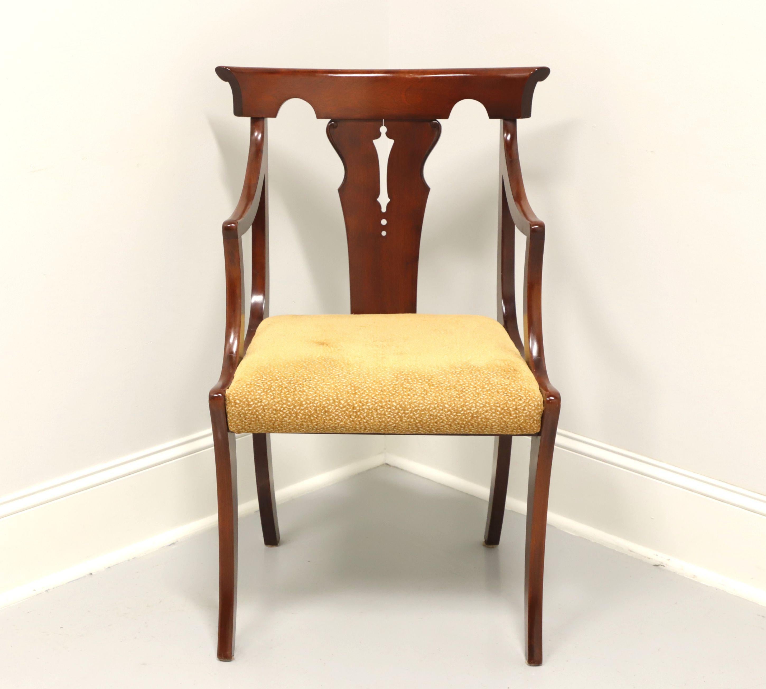 A dining armchair in the Empire style, unbranded. Solid cherry with carved barback crest rail, carved backrest, curved arms, upholstered seat in a gold colored textured fabric and gently curved legs with rear stretcher. Made in USA, in the mid 20th