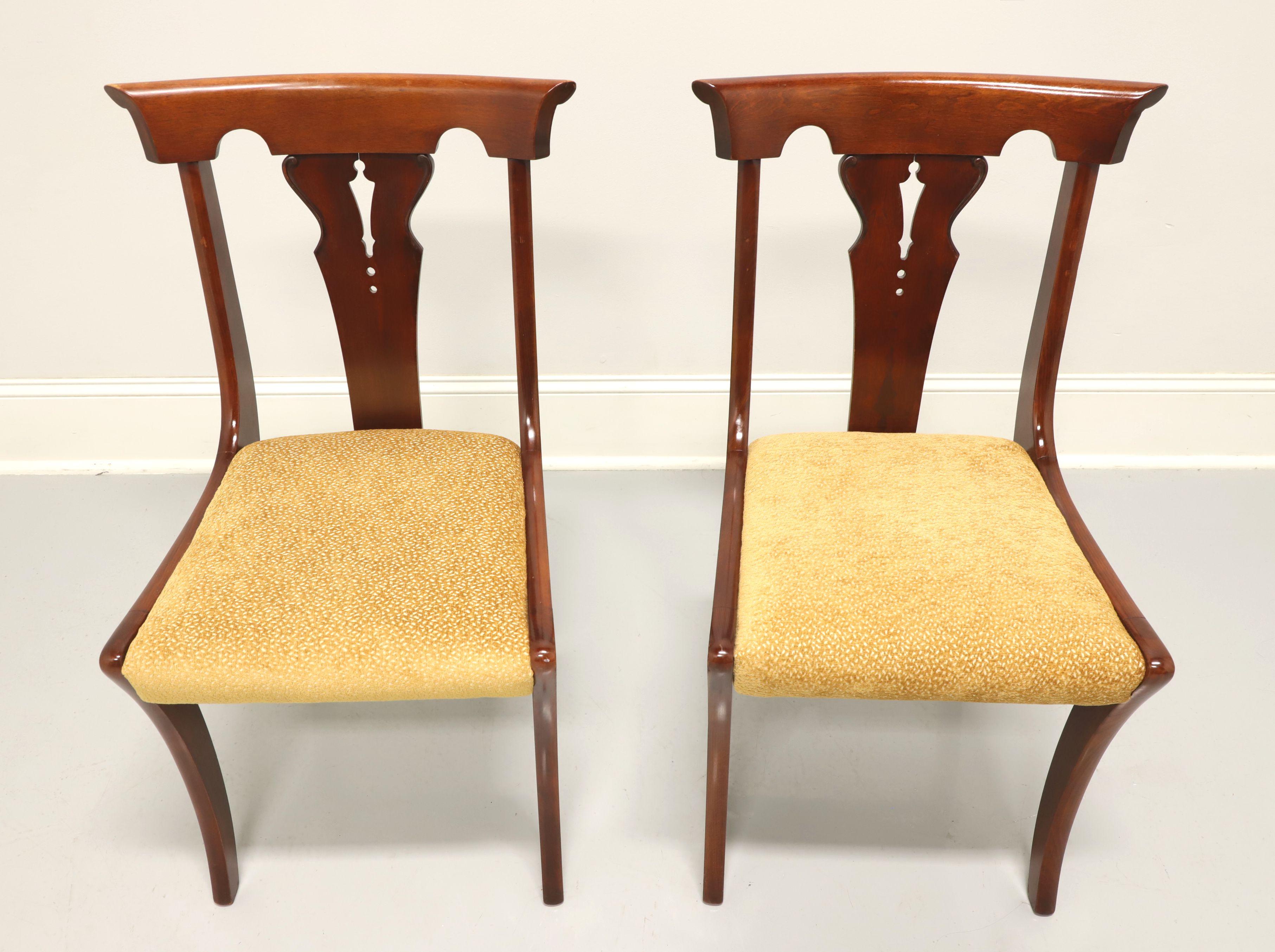 Une paire de chaises latérales de style Empire, sans marque. En merisier massif, il présente une traverse de crête sculptée, un dossier sculpté, une assise tapissée d'un tissu texturé de couleur or et des pieds légèrement incurvés avec une civière