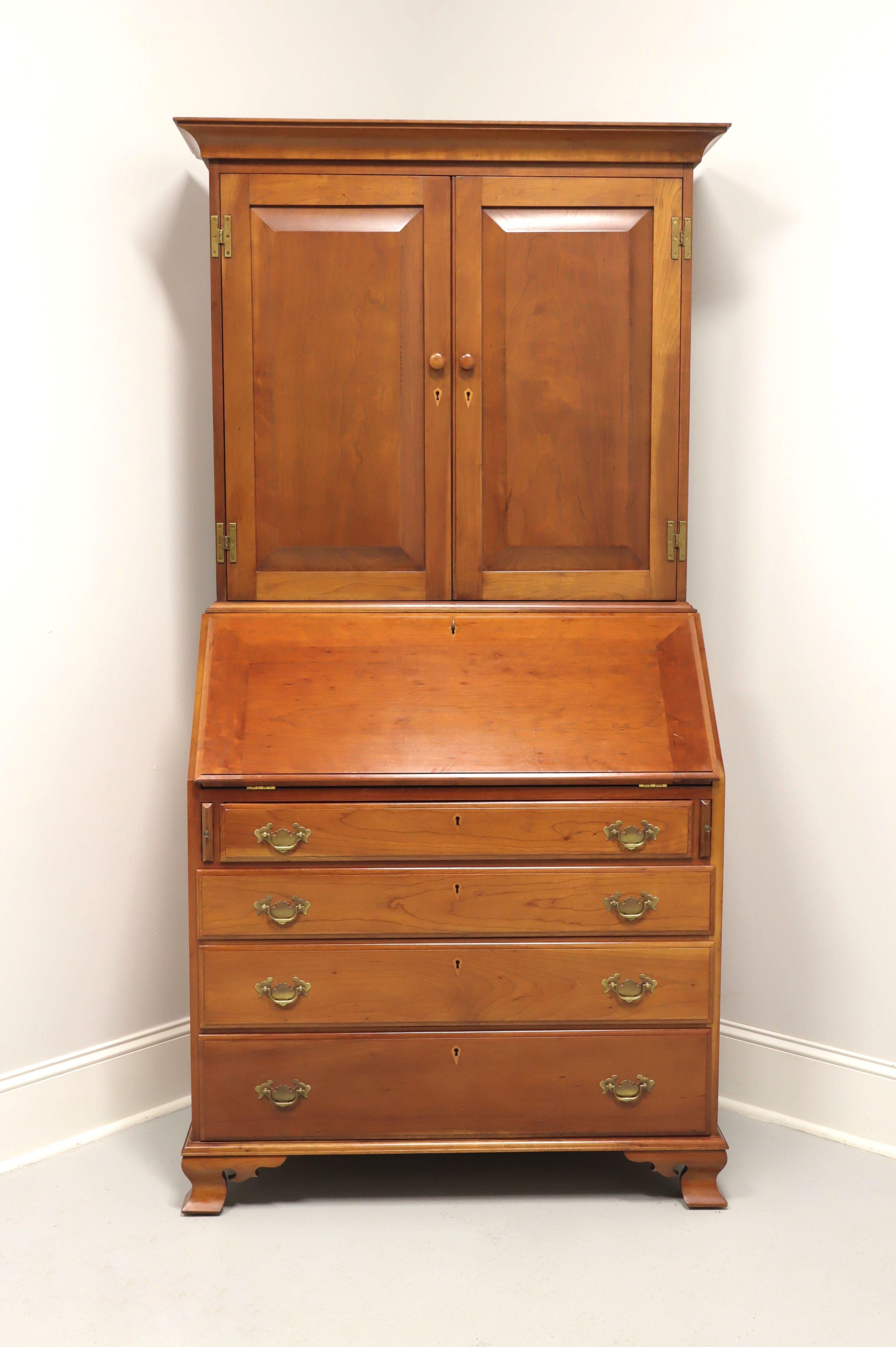 A Chippendale style secretary desk, no branding marks found, attributed to Benbow's. Solid cherry with brass hardware, crown moulding to top and ogee bracket feet. Upper blind bookcase has two doors with faux keyhole escutcheons that reveal two