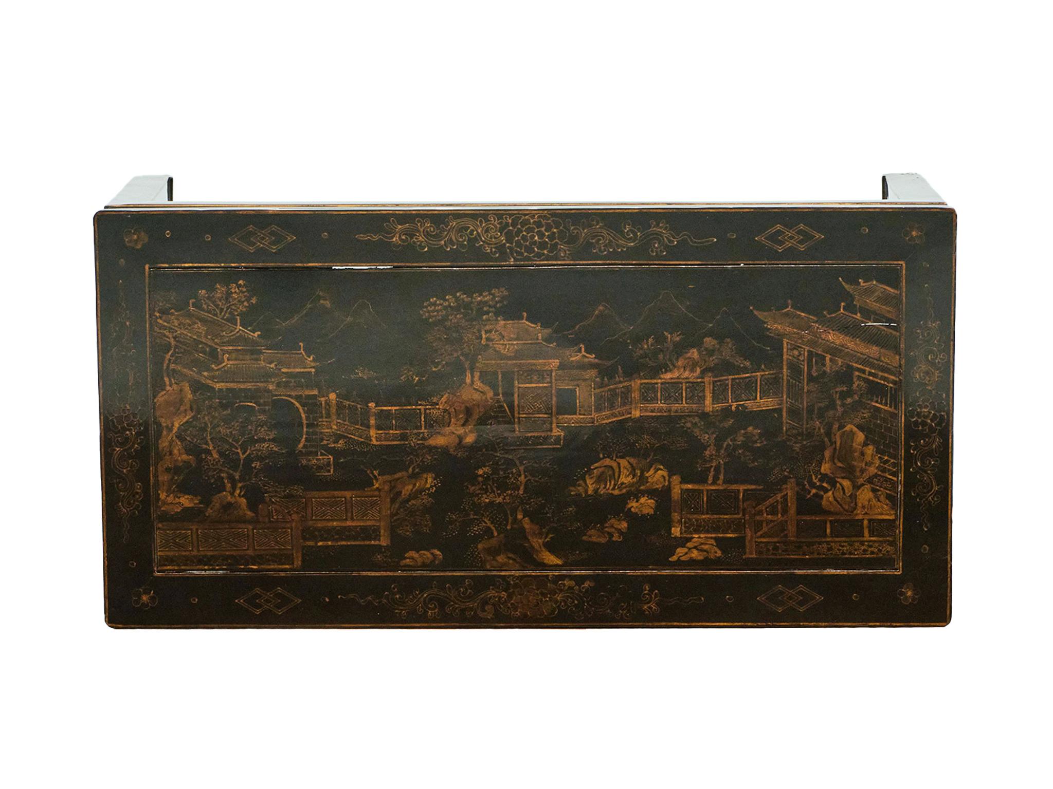 Fabriquée à la main au milieu du XXe siècle, cette table basse chinoise est magnifiquement laquée en noir et peinte à la main avec des dorures. La surface est ornée d'un dessin complexe représentant une cour panoramique avec des montagnes au loin.