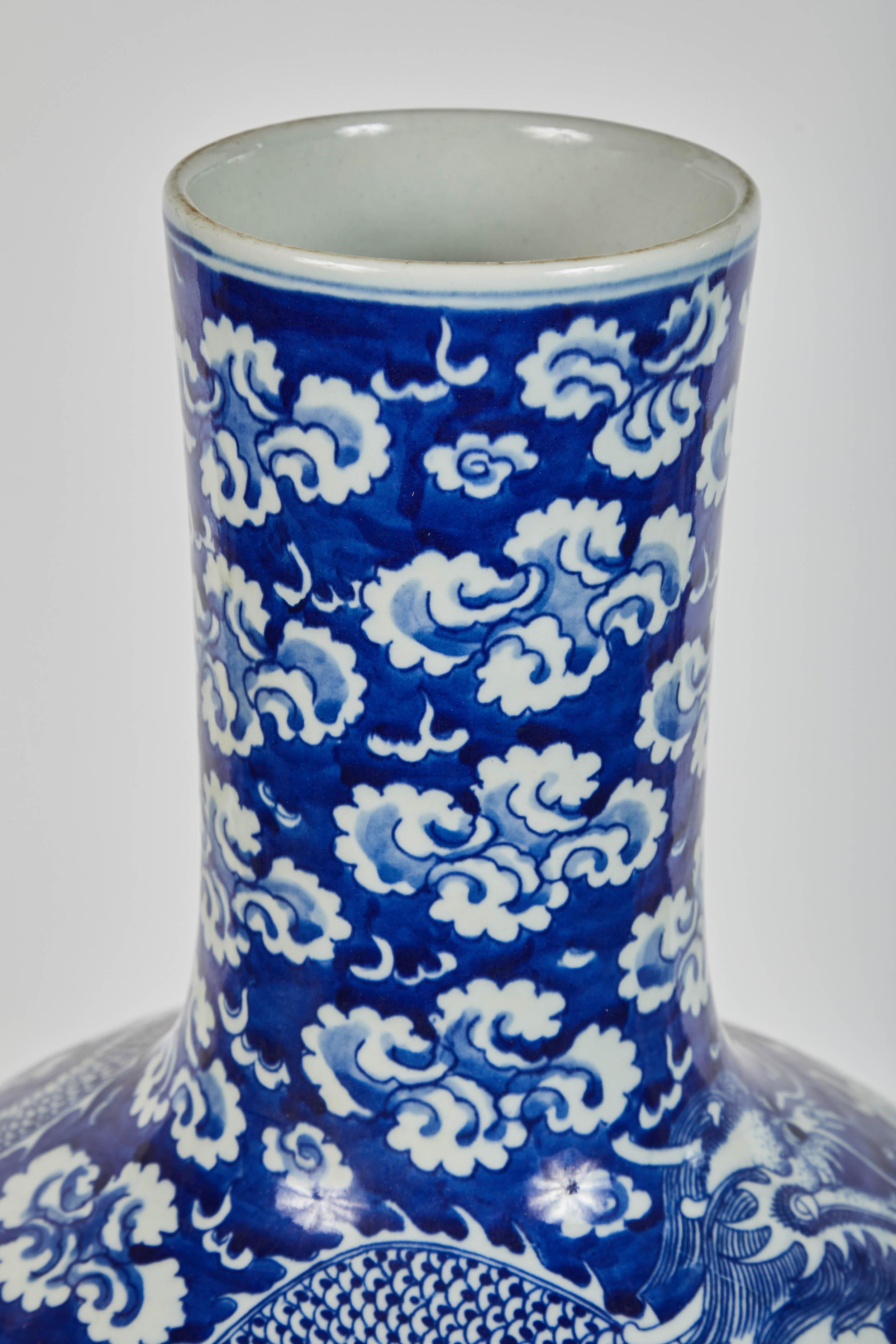 Feine chinesische Porzellanvase aus der Mitte des 20. Jahrhunderts in blau-weißer traditioneller Kalebassenform mit einem großen vierköpfigen Drachen. Schönes Wolkenmotiv.
