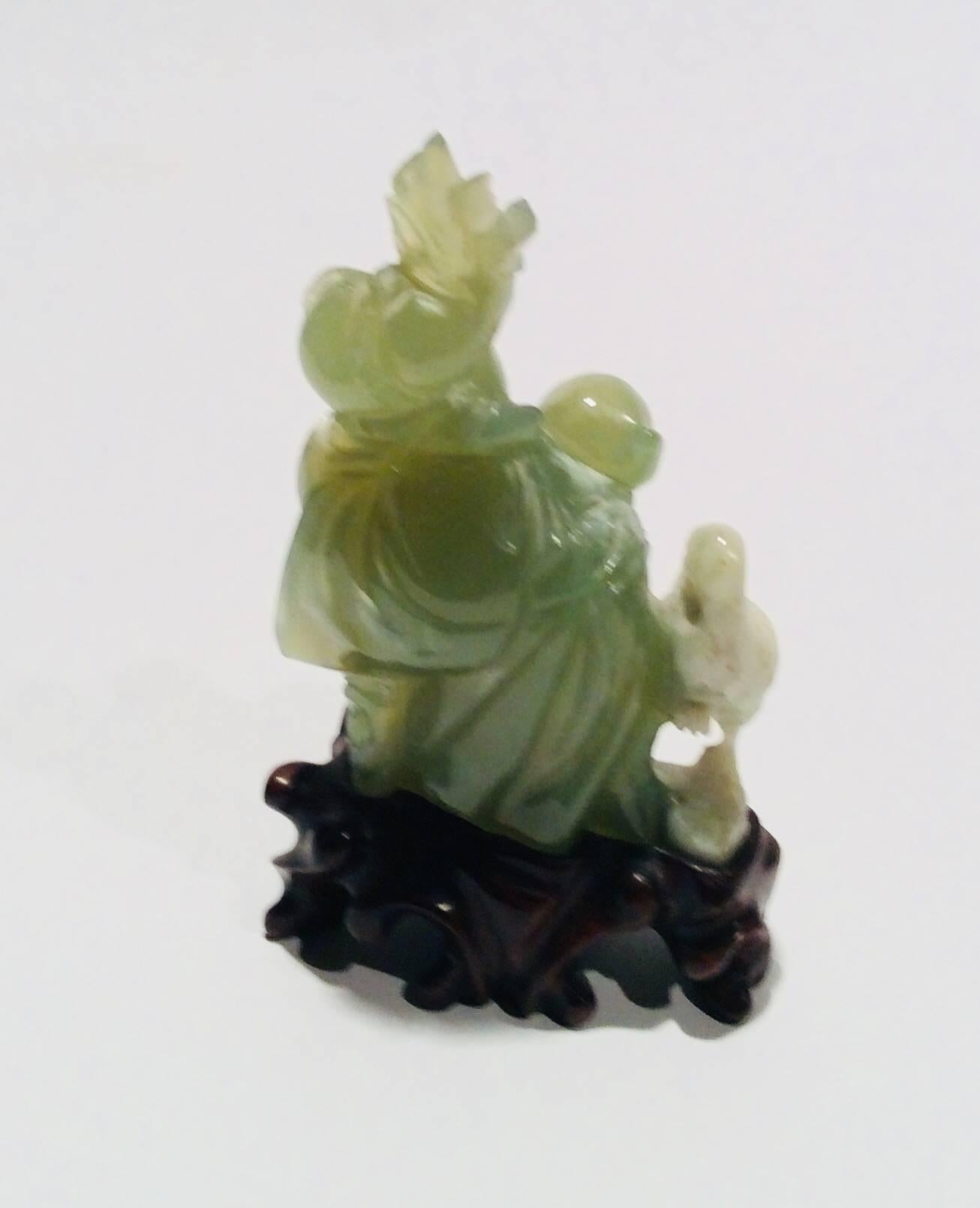 What is unique about this piece is that it is carved from one piece of bowenite. The portion which the wise man is carved from is a stunning clear green where the crane is more of a cloudy white. This is vintage bowenite purchased in Hong Kong after