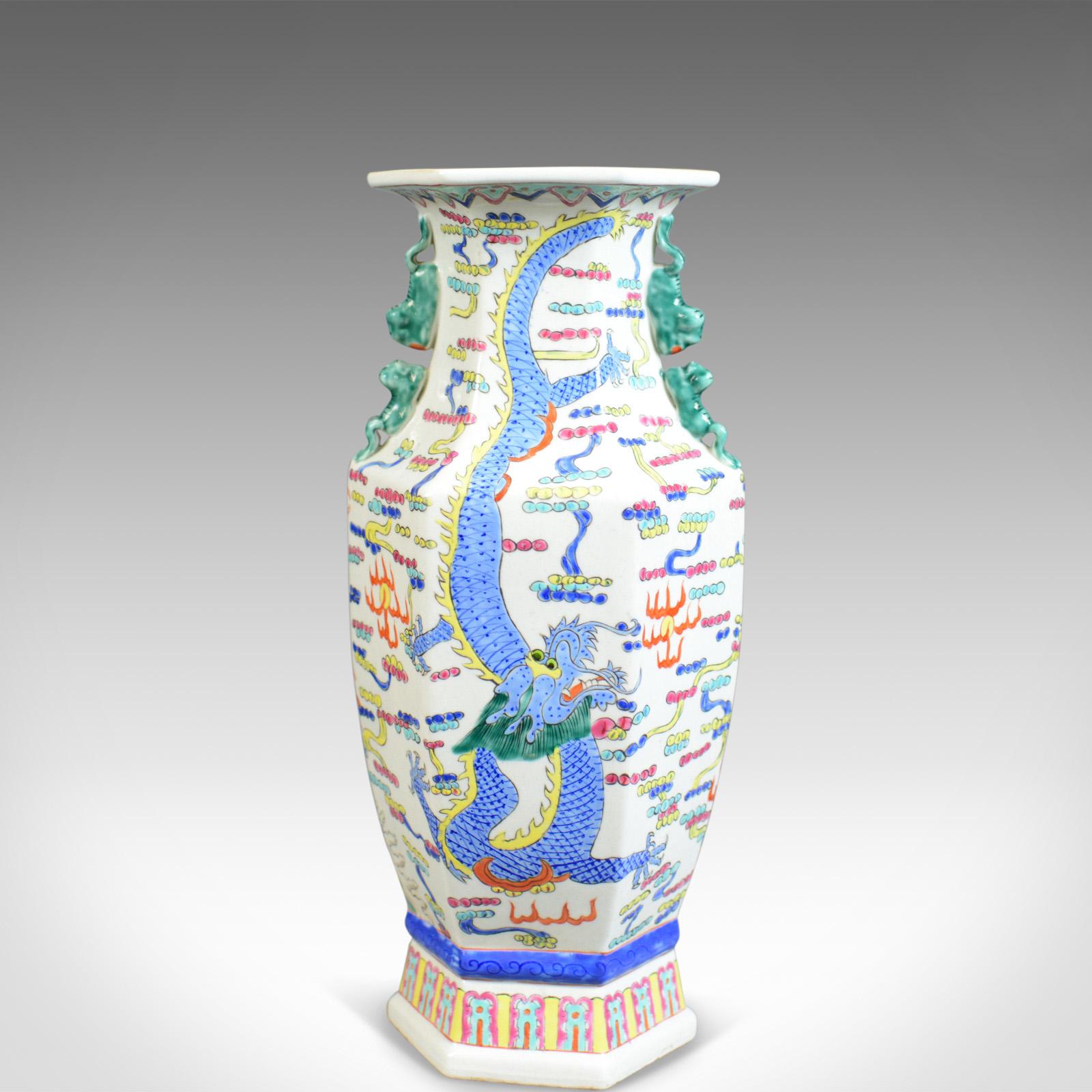 This is a midcentury Chinese hexagonal baluster vase, a 20th century, oriental ceramic urn. 

Imposing quality ceramic vase
Profusely decorated from neck to base
Free-from any damage or marks, unmarked base

Opposing red and blue dragons on a