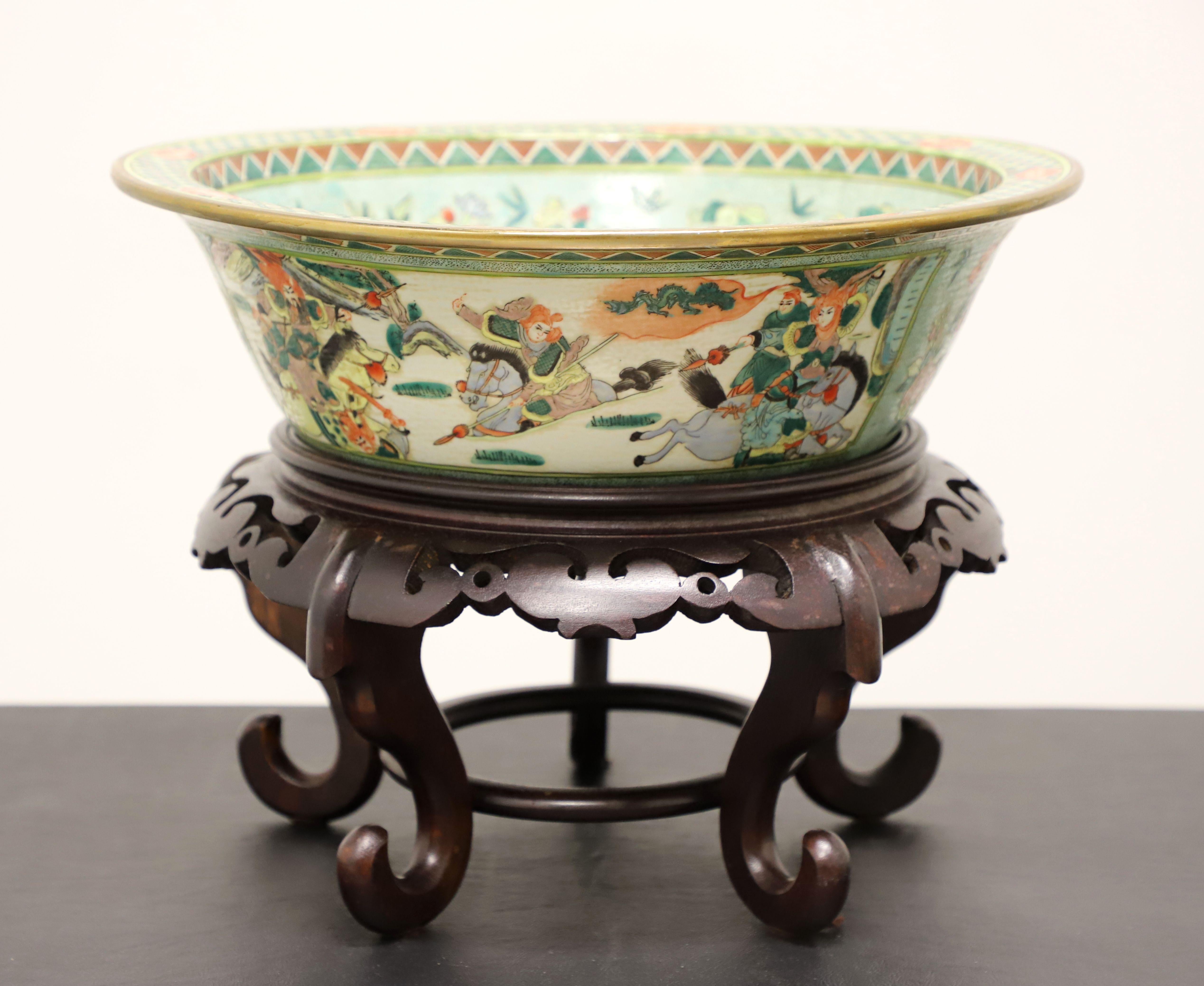 A Mid 20th Century Asian style decorative porcelain bowl with stand, unbranded. A beautiful multi-color porcelain round bowl with hand painted Chinoiserie scenes, a rough textured finish, and a separate decoratively carved round wood stand. Painted