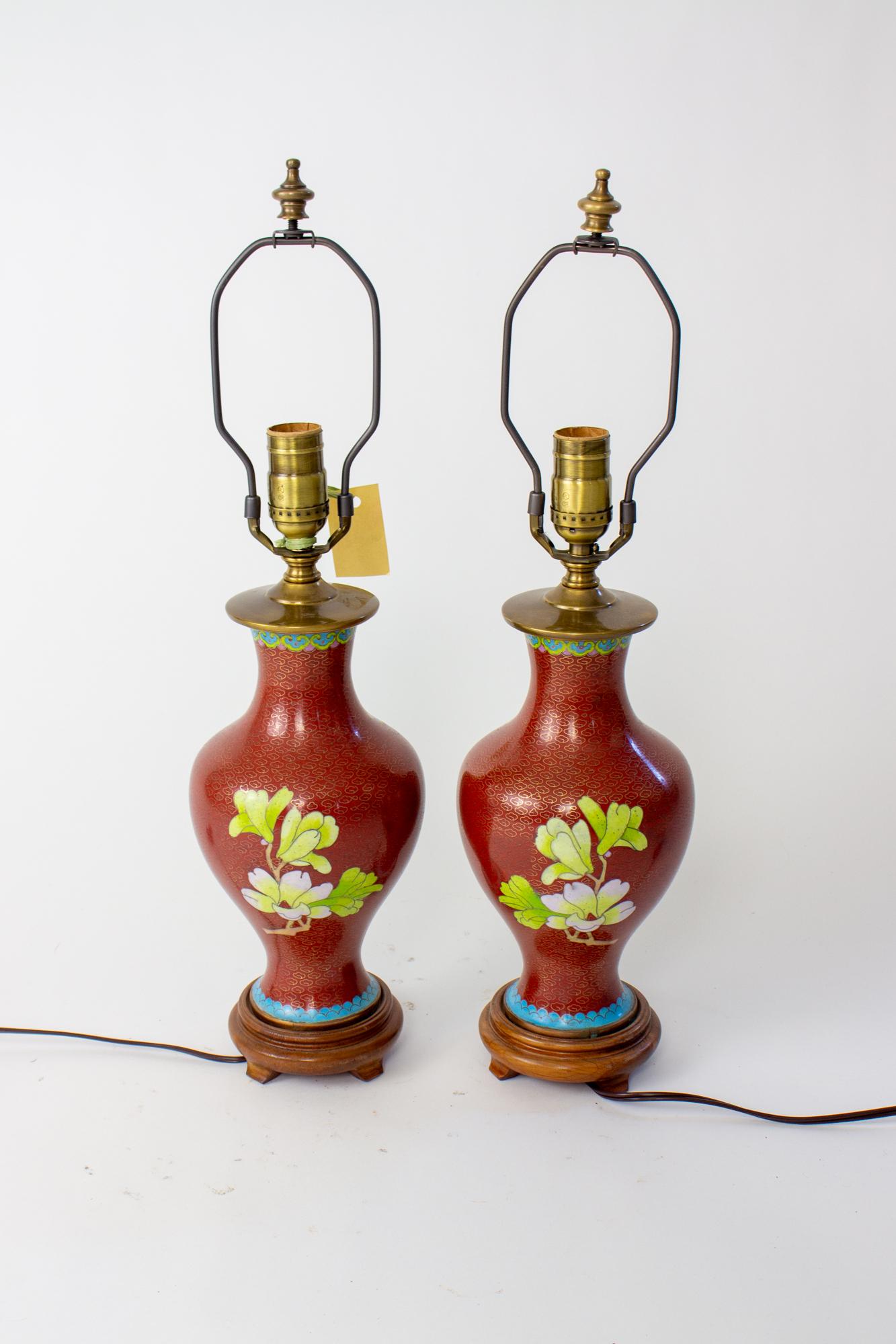 Mid 20th Century chrysanthemum cloisonne table lamps, a pair. Brick red background with orange and pink chrysanthemums, an orange and black butterfly, and magnolia blossoms on the back. Accent colors of green and bright blue. Mid 20th Century
