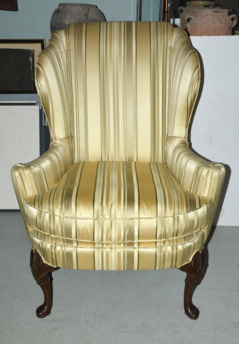 The classically elegant American wingback chair is upholstered for deep comfort in a green and yellow stripped faux satin fabric. The 