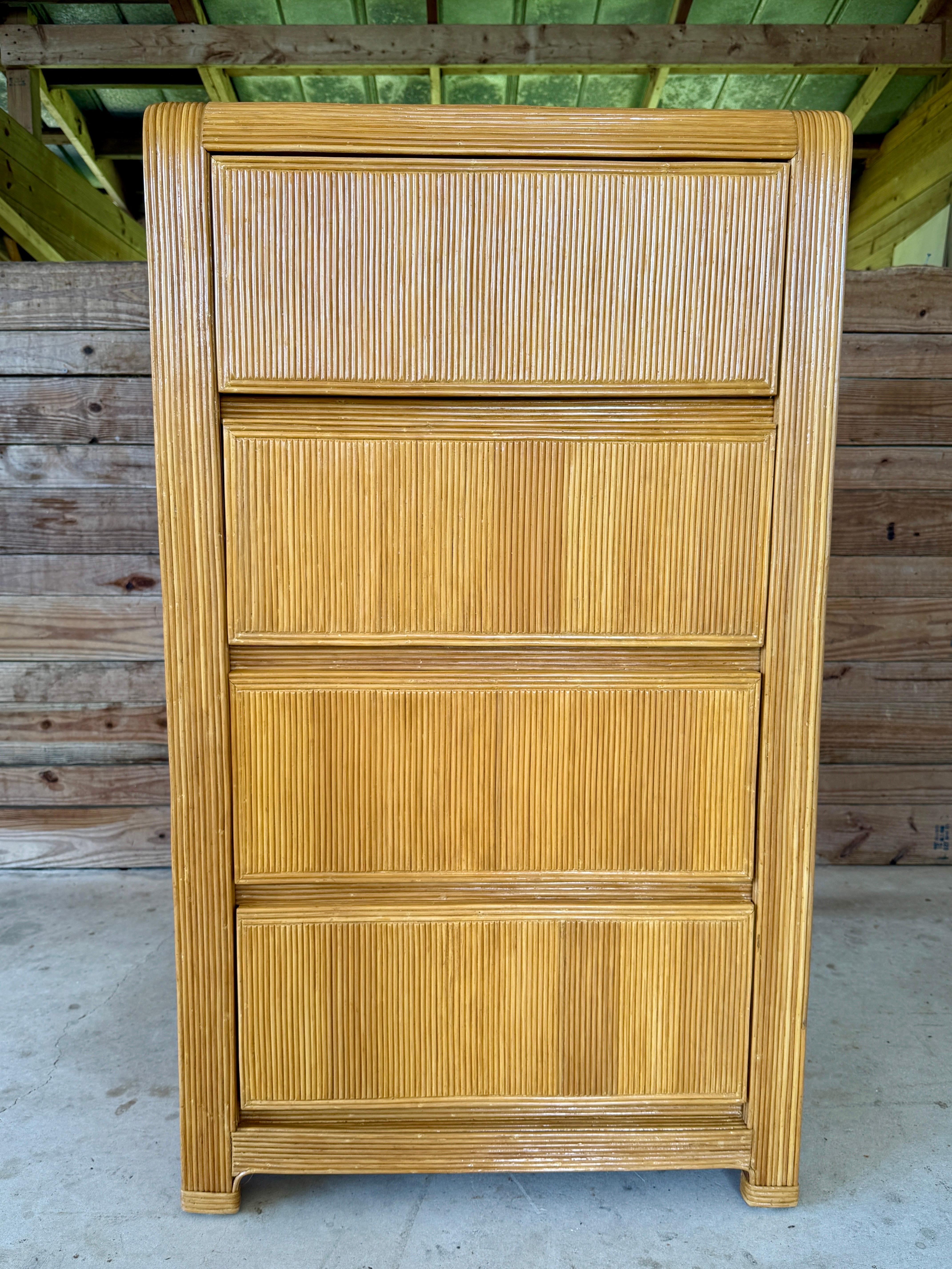 Bellissima cassettiera in rattan a matita della metà del XX secolo, caratterizzata da un design elegante e dai bordi arrotondati con dettagli verticali in giunco. Completamente rifinito, mette in risalto i toni dorati naturali e la texture organica