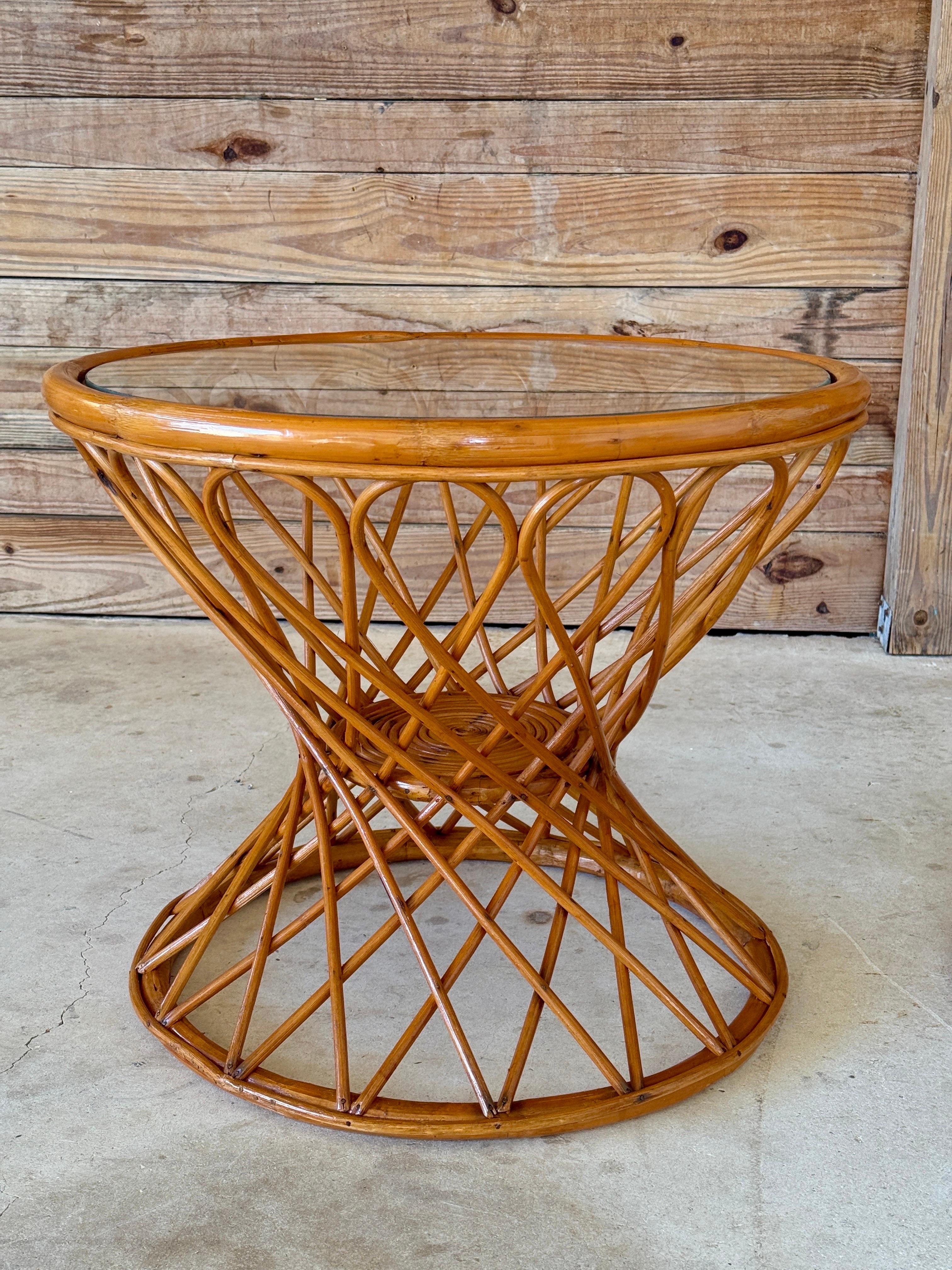 Élégante et sculpturale, cette paire de tables d'appoint en rotin du milieu du XXe siècle présente une silhouette en sablier accrocheuse avec un motif de treillis entrelacé. La rénovation légère met en valeur les tons naturels et la chaleur du