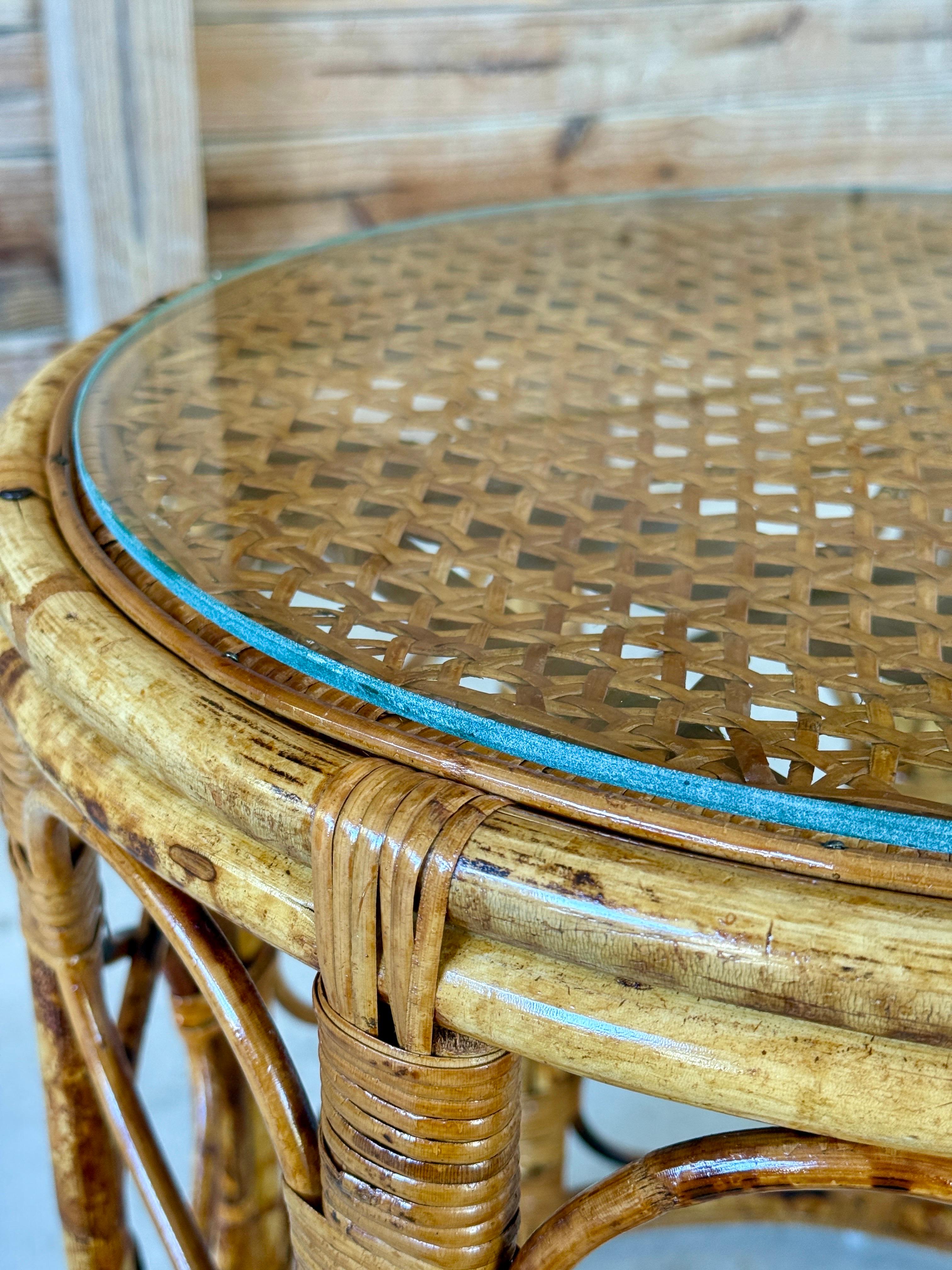 Mesa de tambor de ratán tortuga bellamente restaurada, con tablero de caña tejida protegido por cristal redondo nuevo. El marco presenta un llamativo diseño de lazo abierto, que resalta las variaciones naturales y la calidez del ratán.
- Periodo: