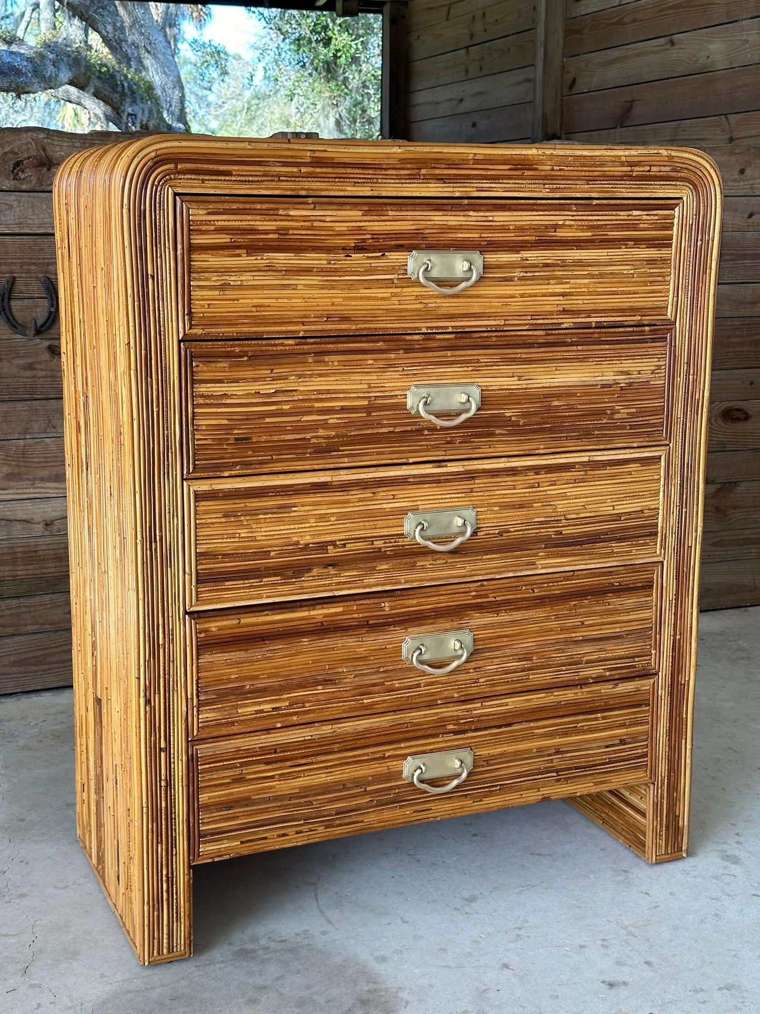 Stunning vintage waterfall pencil Reed rattan chest of drawers with five drawers and original polished brass pulls.
Beautifully refinished but leaving in a vintage state and always a classic piece in any room for a coastal style.
Drawers open and