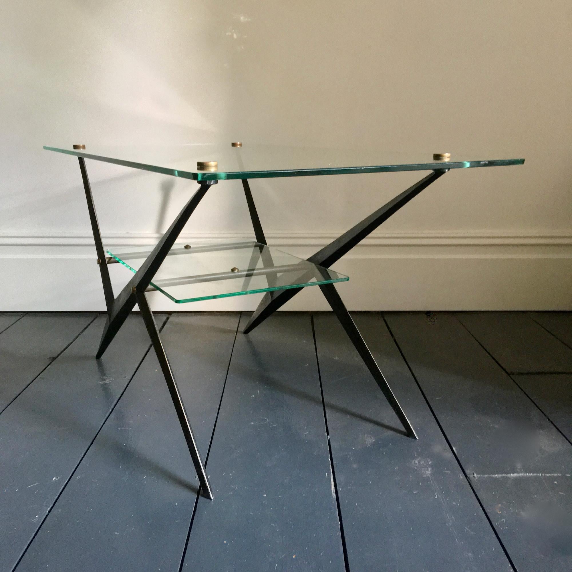 Elegant coffee table or side table designed by Angelo Ostuni; black lacquered metal frame with brushed finish, brass fixings and two glass tiers.

The piece is in very nice original condition. In line with age, there are signs of wear to both the