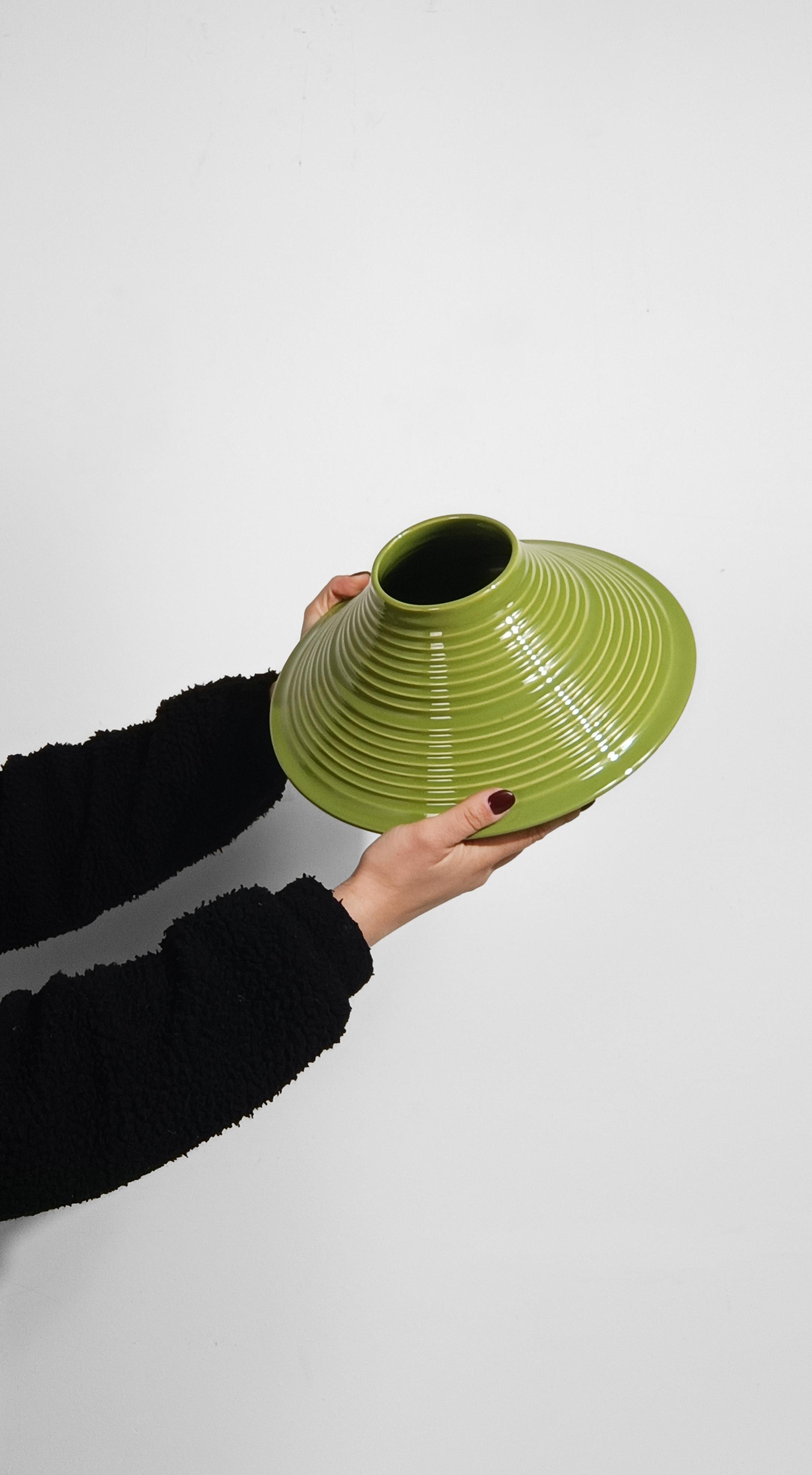 Offriamo in vendita uno splendido vaso conico smaltato in verde pera e risalente alla metà del XX secolo.
Molto probabilmente realizzato in Italia, dove lo abbiamo acquistato, questo vaso vintage ha una struttura a più livelli: globoso alla base, si