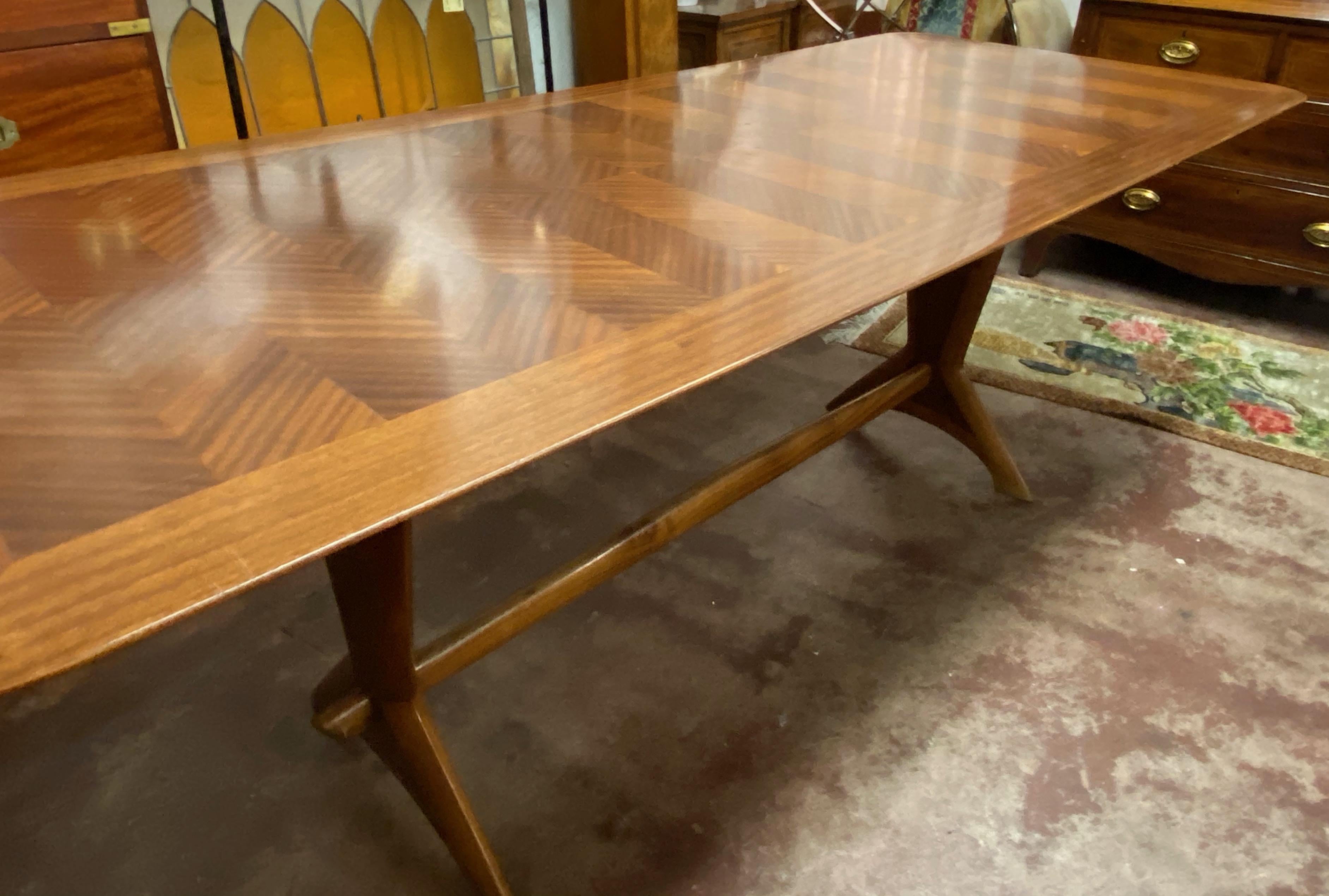 Mid-20th century cross banded mahogany trestle base dining table, circa 1950s.

Classic Danish modern styling with a cross banded mahogany top. The table is quality built by talented cabinetmakers.

The top of the table shows various scuff marks