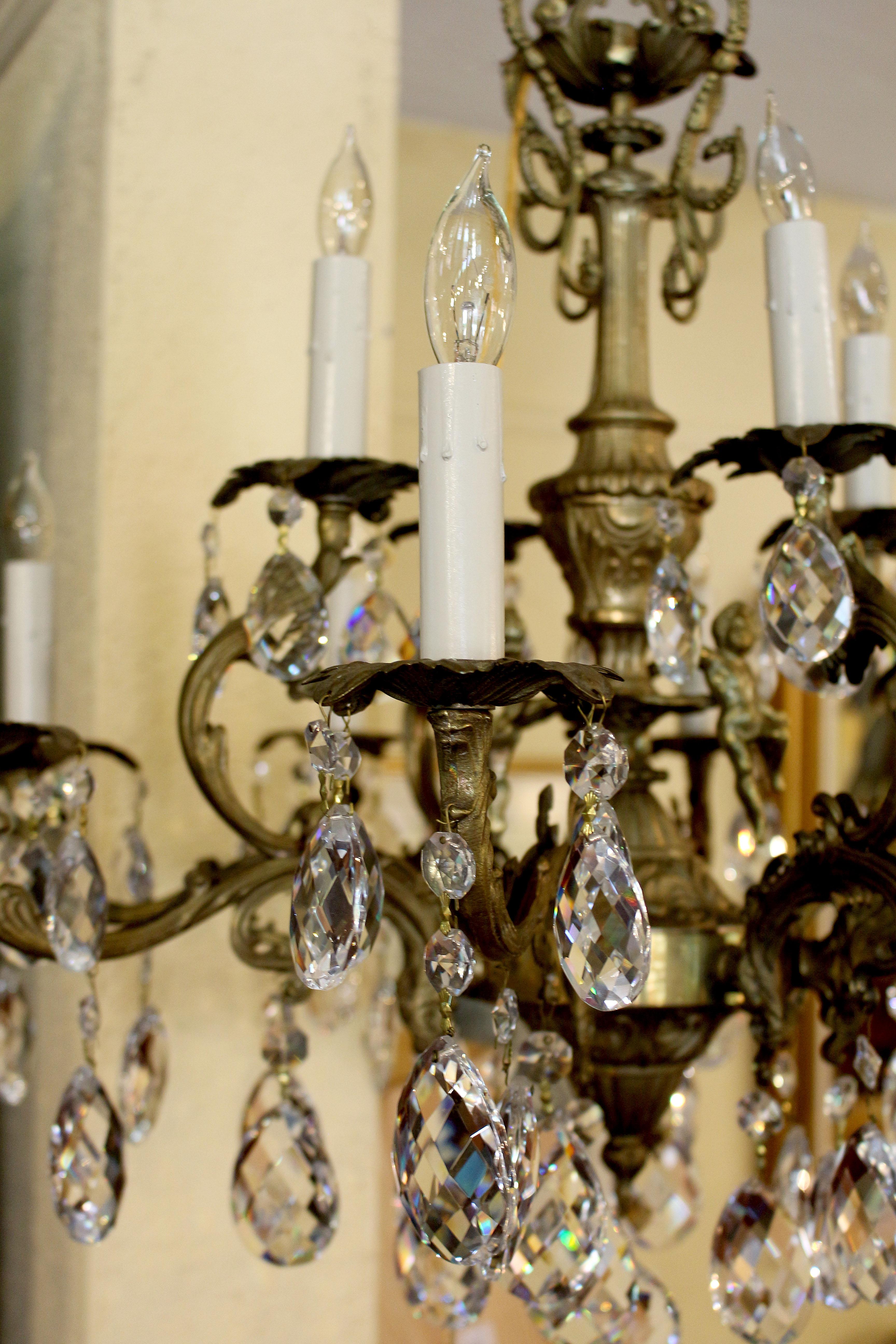 Crystal & bronze 12-light chandelier. Bronze central shaft adorned with three putti. Probably Italian, mid-20th century. 24