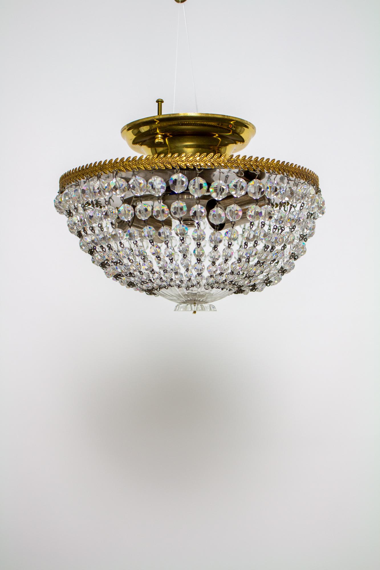 Crystal basket fixture with two lights. Ring is a stamped gold, interior is chrome plated to reflect light. Graduated strands of crystals hang from the rings and gather below, at a round cut glass dish. Cleaned and rewired, complete and ready to