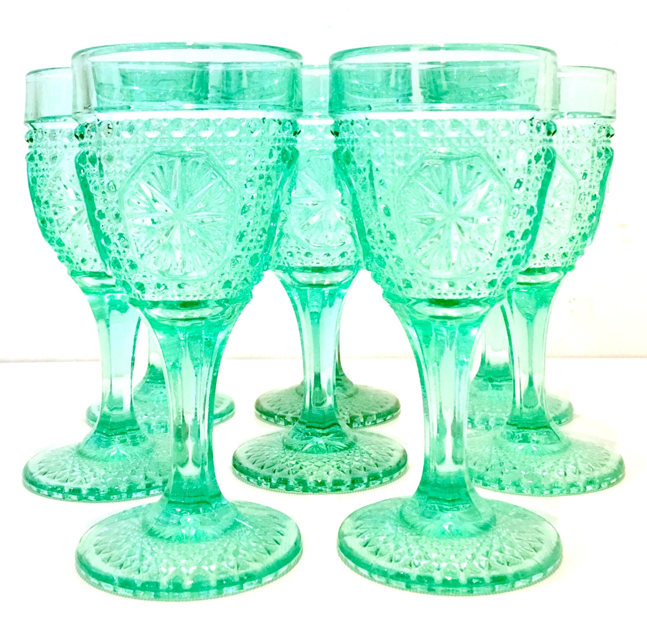 Mid-20th Century American cut pressed glass textured aqua green stem drinking glasses, set of eight pieces. These lovely raised and textured starburst stem glasses feature a cut and faceted stem and raised dot and starburst pattern.