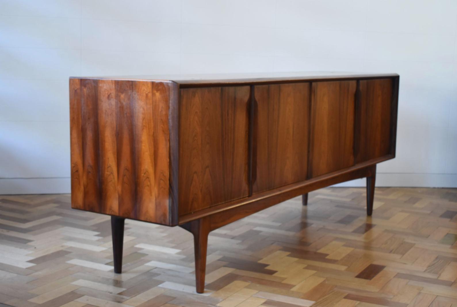 This beautiful rosewood 1960s sideboard is attributed to Arne Vodder. It is in brilliant condition having being newly restored, with a gorgeous deep tone of rosewood with a lovely grain and four green felt lined drawers. The sideboard has sliding