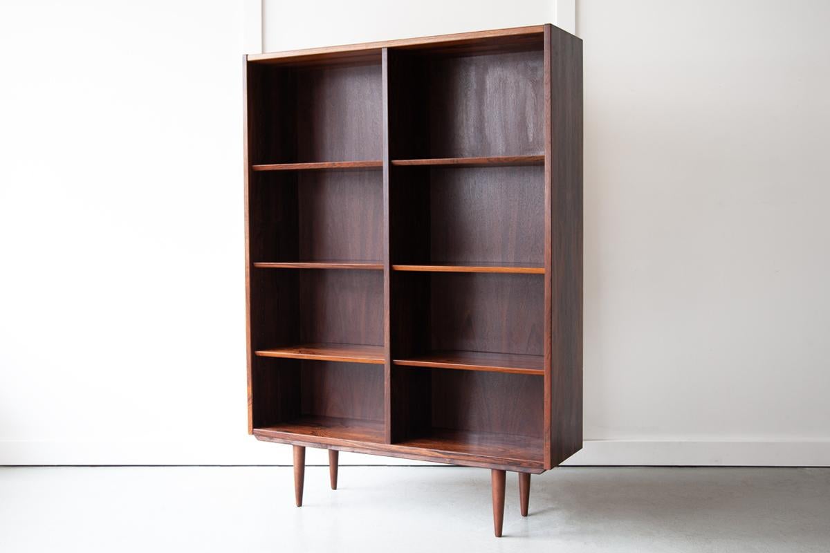 An elegant rosewood bookcase, made in Denmark in the 1960's, with height-adjustable shelves to allow for storage of an array of different sized books and objects. The shelves have stylish chamfered edges, adding to that minimalistic and classically