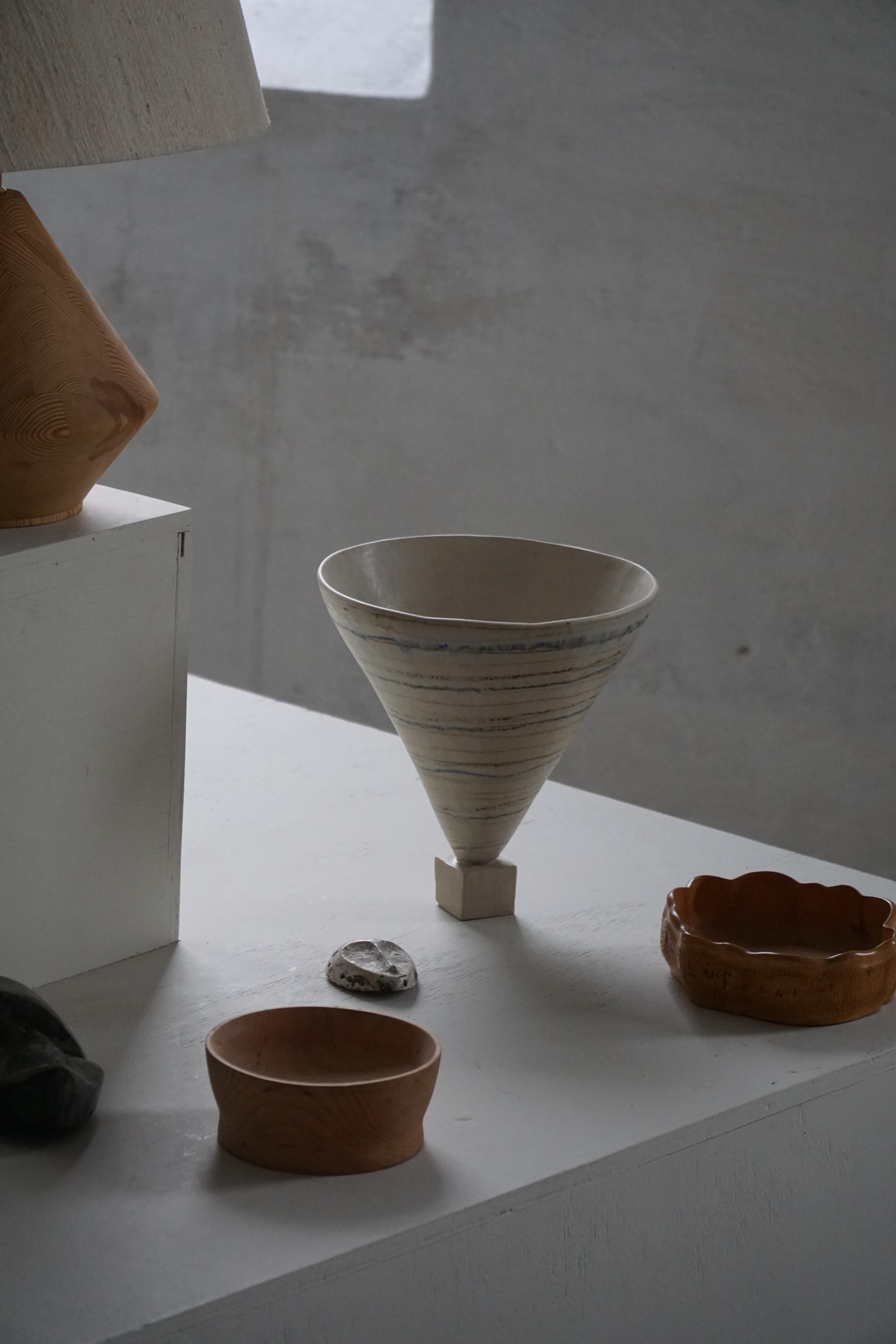 Elegante e scultoreo vaso danese in gres degli anni '60, di autore sconosciuto. La forma è sorprendente e modernista, caratterizzata da un raffinato corpo conico elevato su un piccolo piede geometrico a forma di cubo: un equilibrio giocoso e