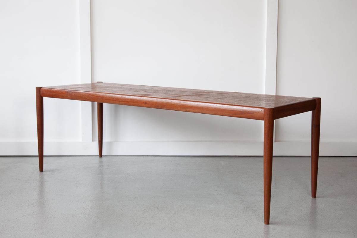 A beautifully elegant Danish coffee table in teak, with a classically minimalist style, that states 'less is always more'. The richly grained table top stands on tapering legs.