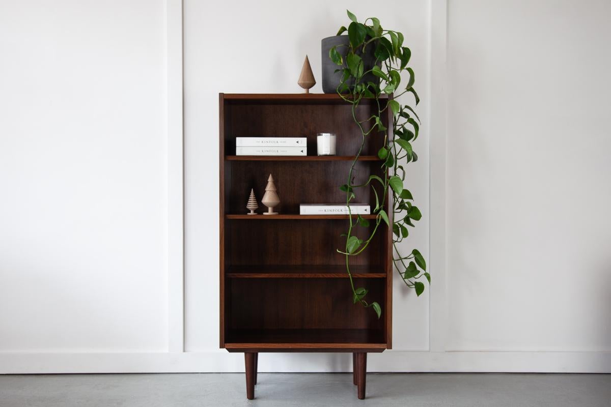 A beautiful and compactly sized Danish bookcase in rosewood, with wonderful grain detailing. The shelves are adjustable for functionality, so can be moved up and down to suit. Manufactured by Hundevad, Denmark in the 1960's. 

