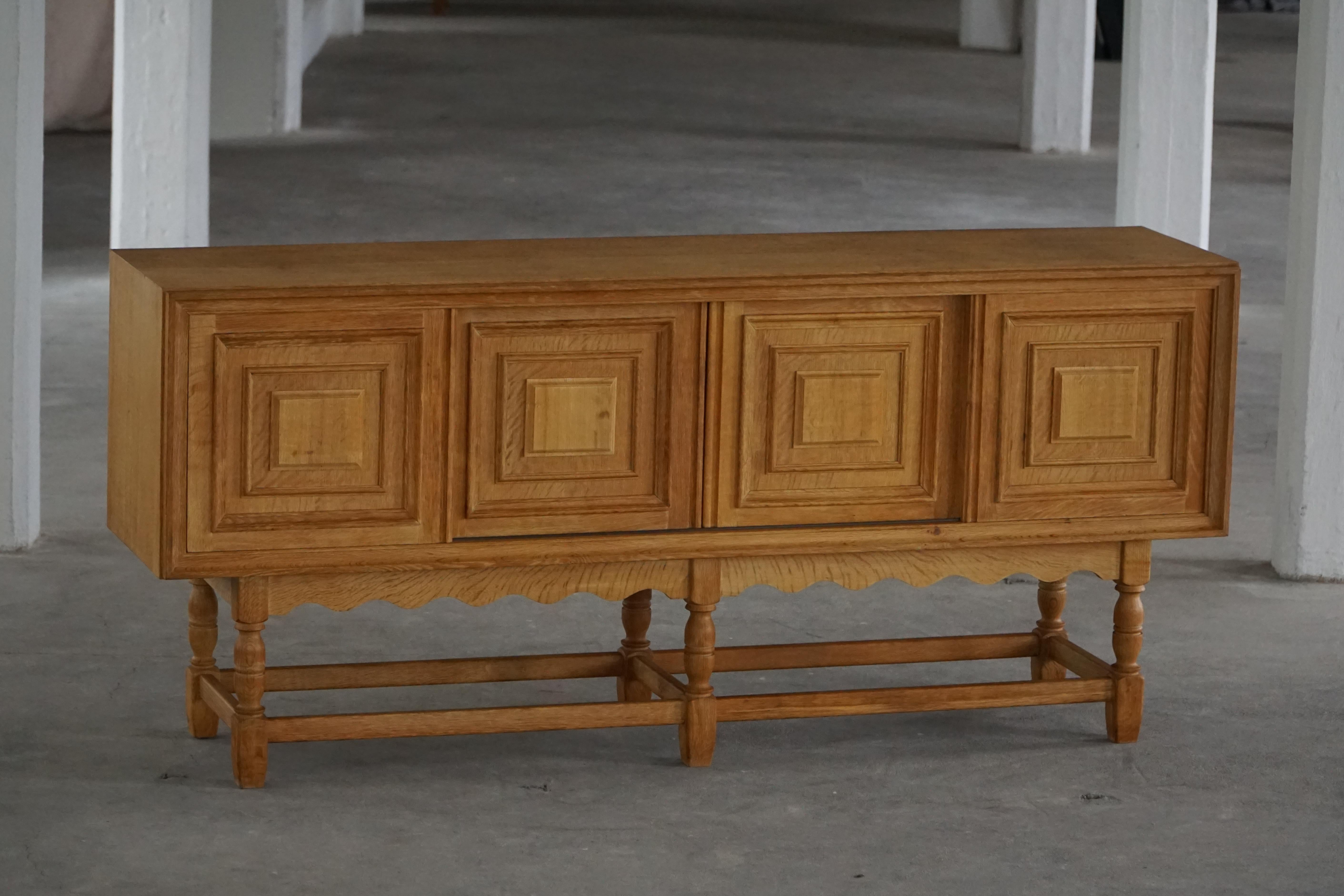 An exceptional oak sideboard designed by a Danish cabinetmaker during the 1950s. Executed in solid and veneered oak, the piece showcases the traditional Danish craftsmanship and functional modernism.

The front features four deeply paneled doors