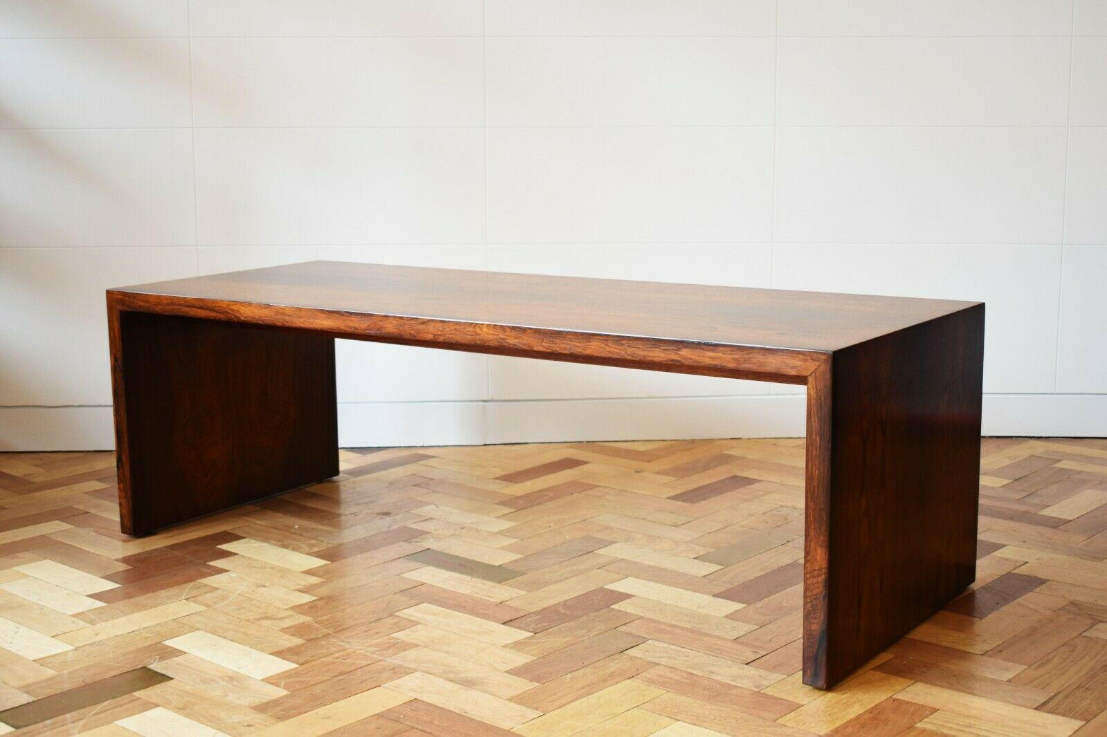 A beautiful and rare rosewood coffee table, boasting a simplistic elegance through it's waterfall design and flowing lines. The rectangular top is raised on solid board, making it a timeless design. 

Fantastic vintage condition with a beautiful