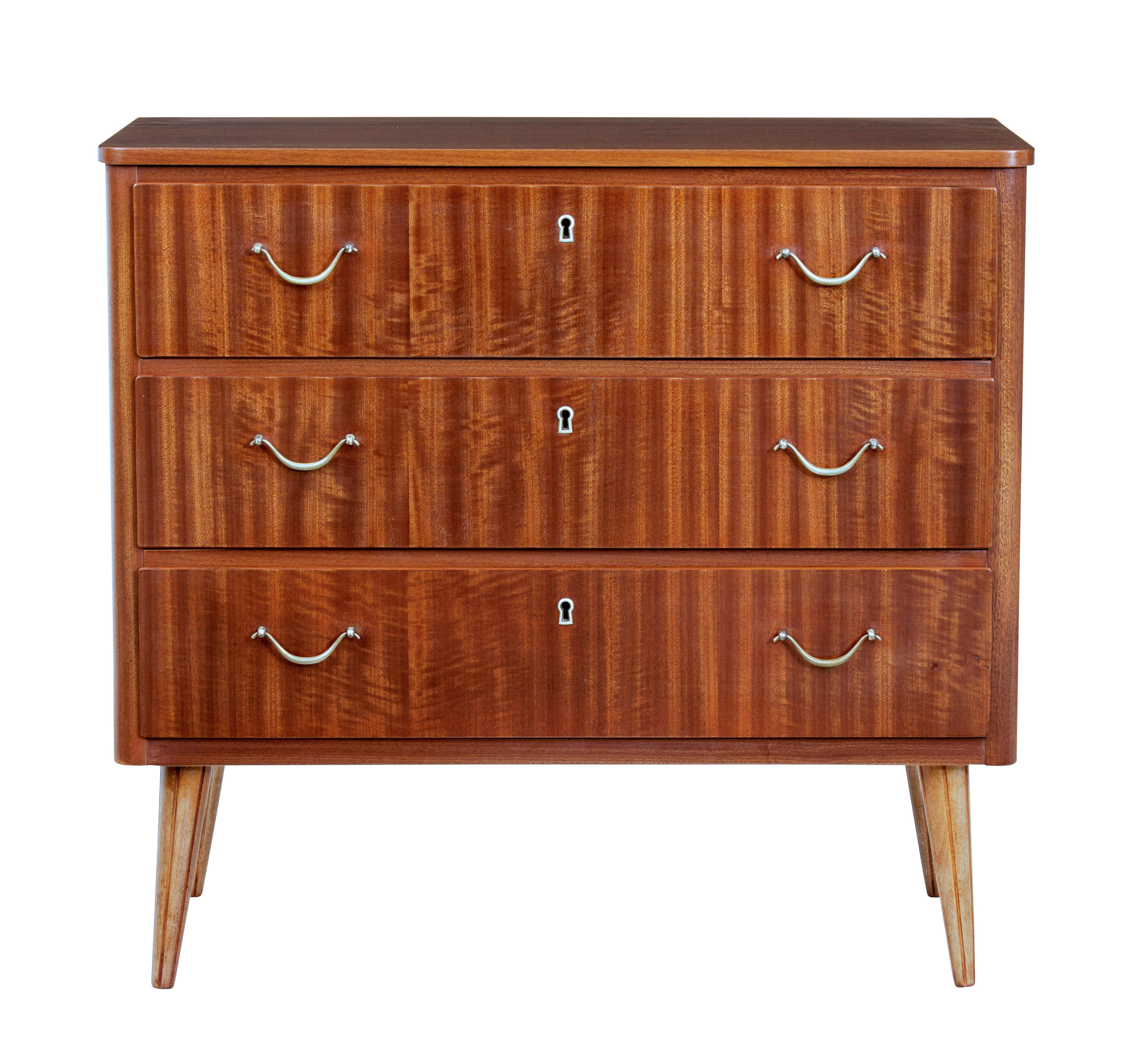 Piccola cassettiera danese in teak della metà del XX secolo, circa 1960.

3 cassetti dotati di maniglie ad anello in ottone.  Colore ricco e superficie lucida, insolita per il teak.

Si regge su gambe affusolate.

Leggera macchia sulla superficie