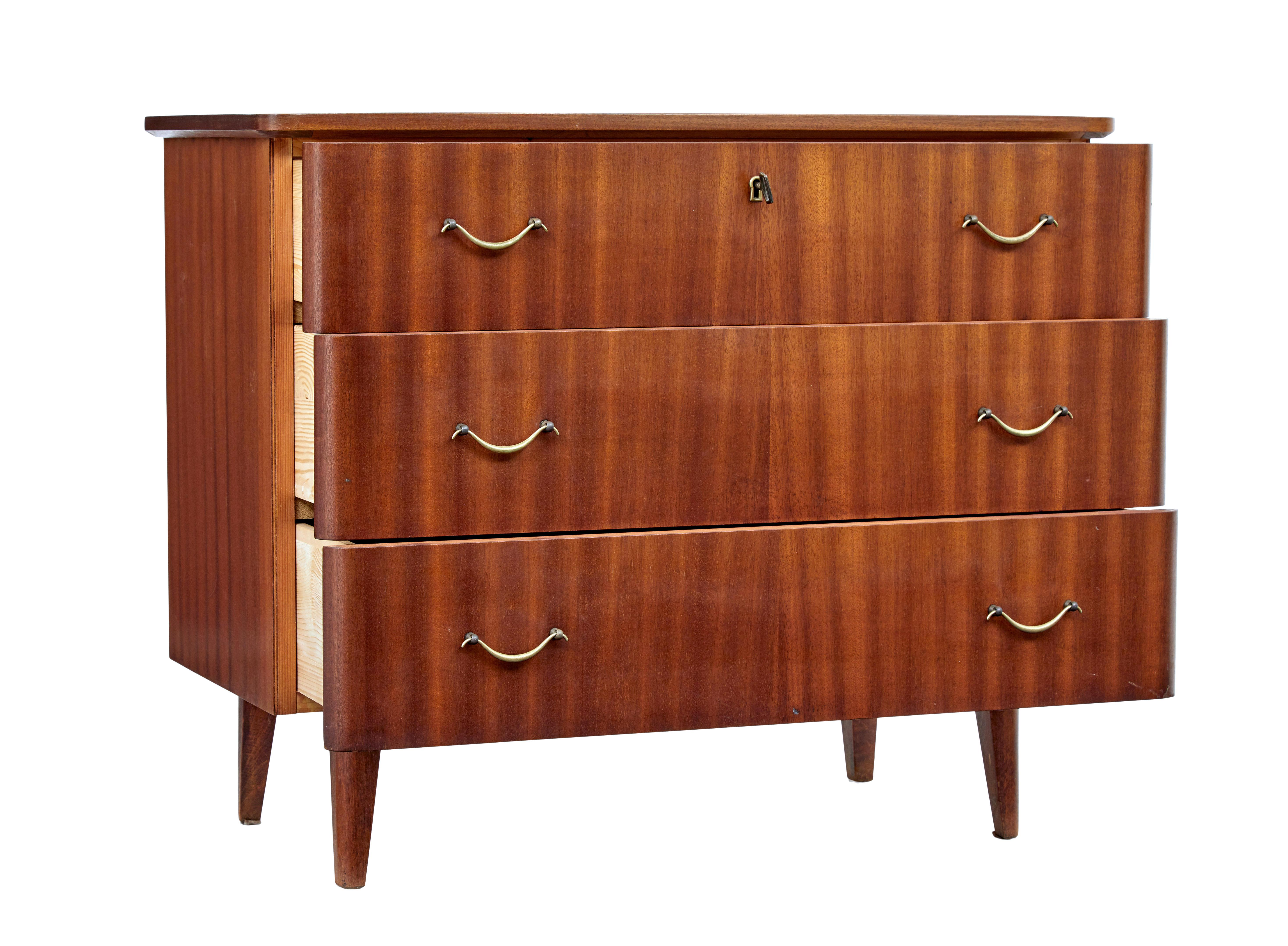 Mid-20th Century Danish teak chest of drawers circa 1960.

3 drawer Scandinavian design chest of drawers from the 1960s. Veneered in teak and fitted with shaped brass handles.  Top drawer with working lock and key for secure storage.  Standing on