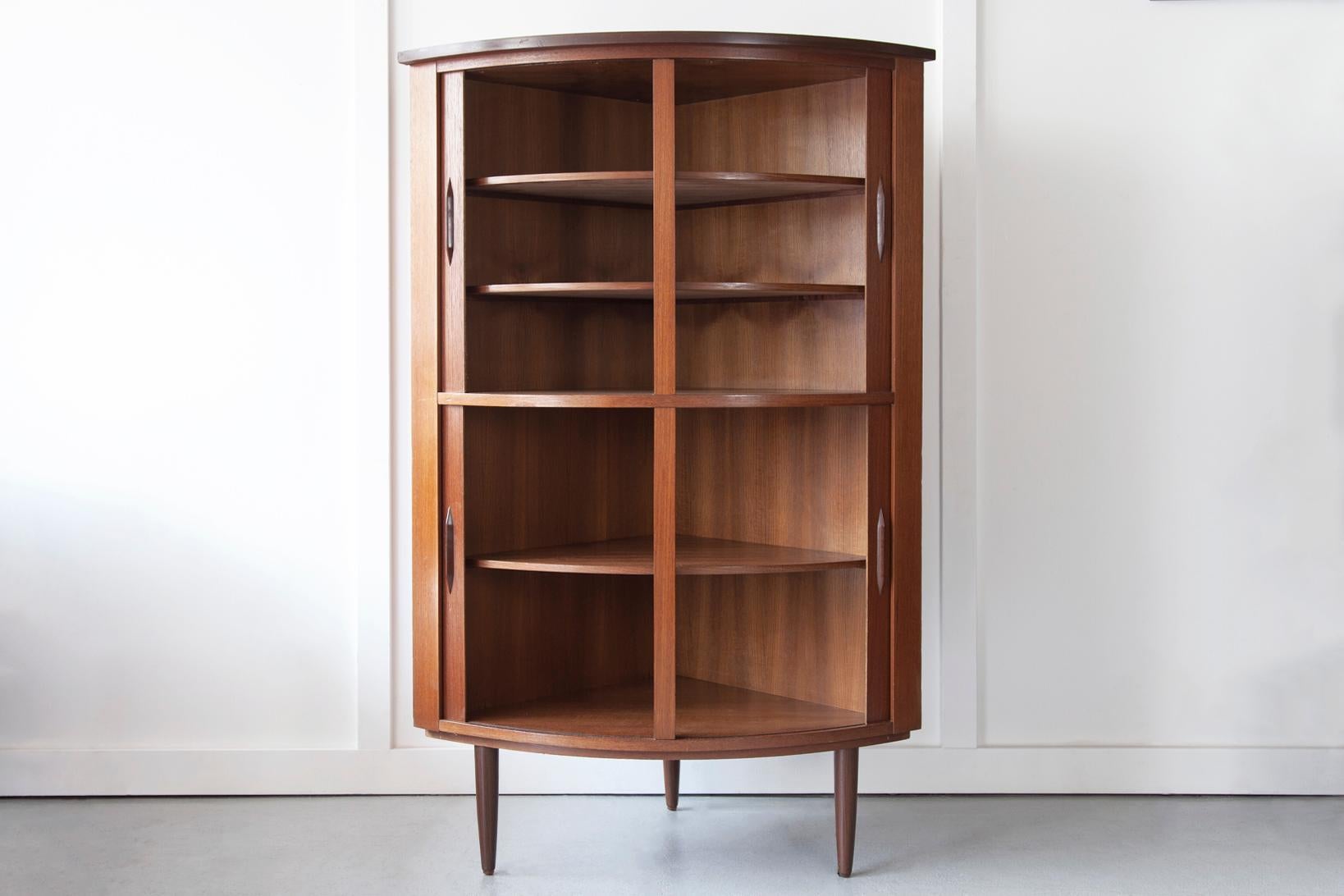 A beautiful and unique Danish teak corner cabinet with stunning tambour doors, curved pulls and internal shelves, produced by Skovmand & Andersen in the 1960s. The upper section has smaller shelf height, perfect for storing glasses whereas the lower