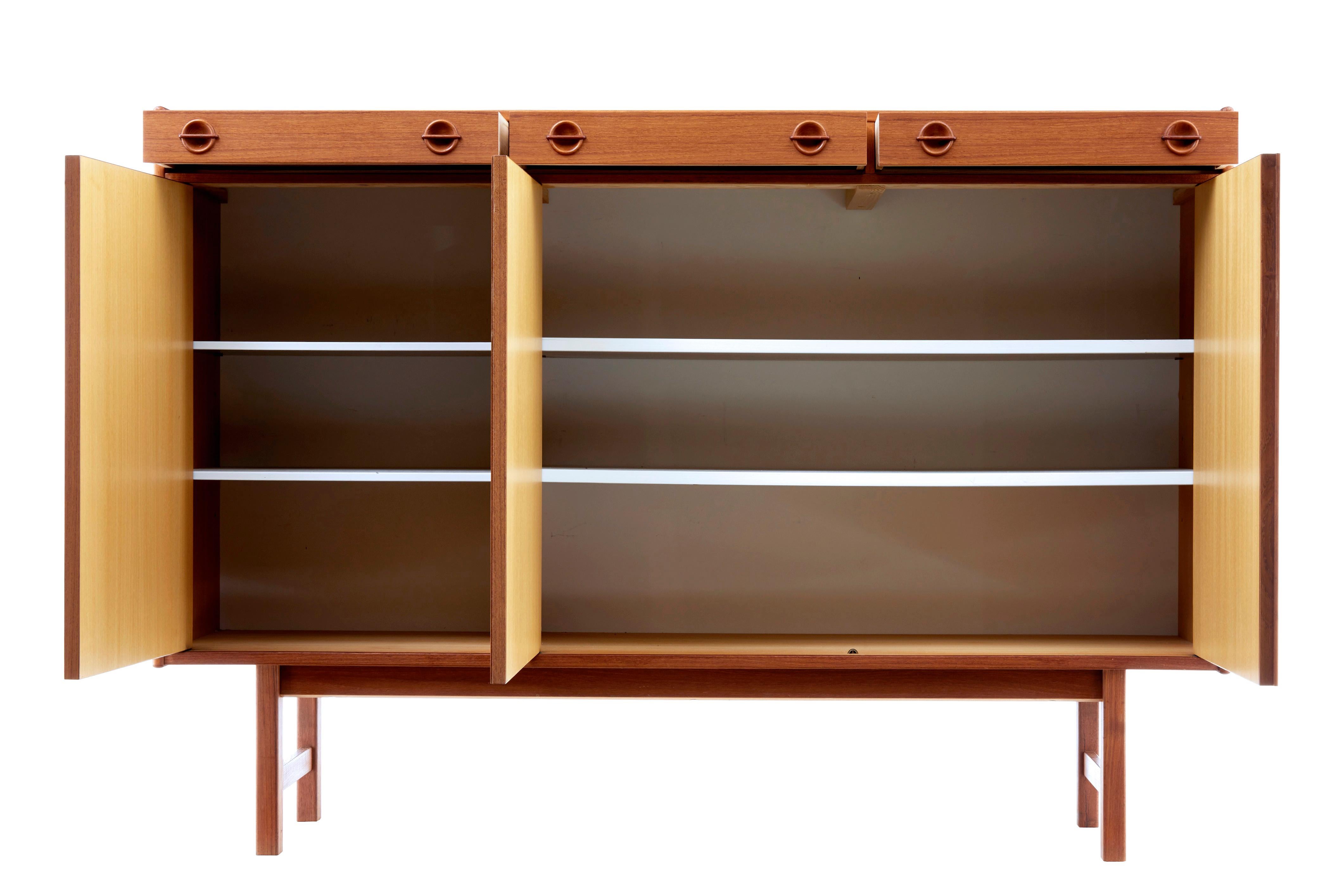 Mid-20th century Danish teak sideboard, circa 1960.

3 drawers in the top, 1 of which has been fitted with compartments and baize for cutlery. Below the drawers are a single and double door cupboard, each containing 2 shelves.

Minor surface