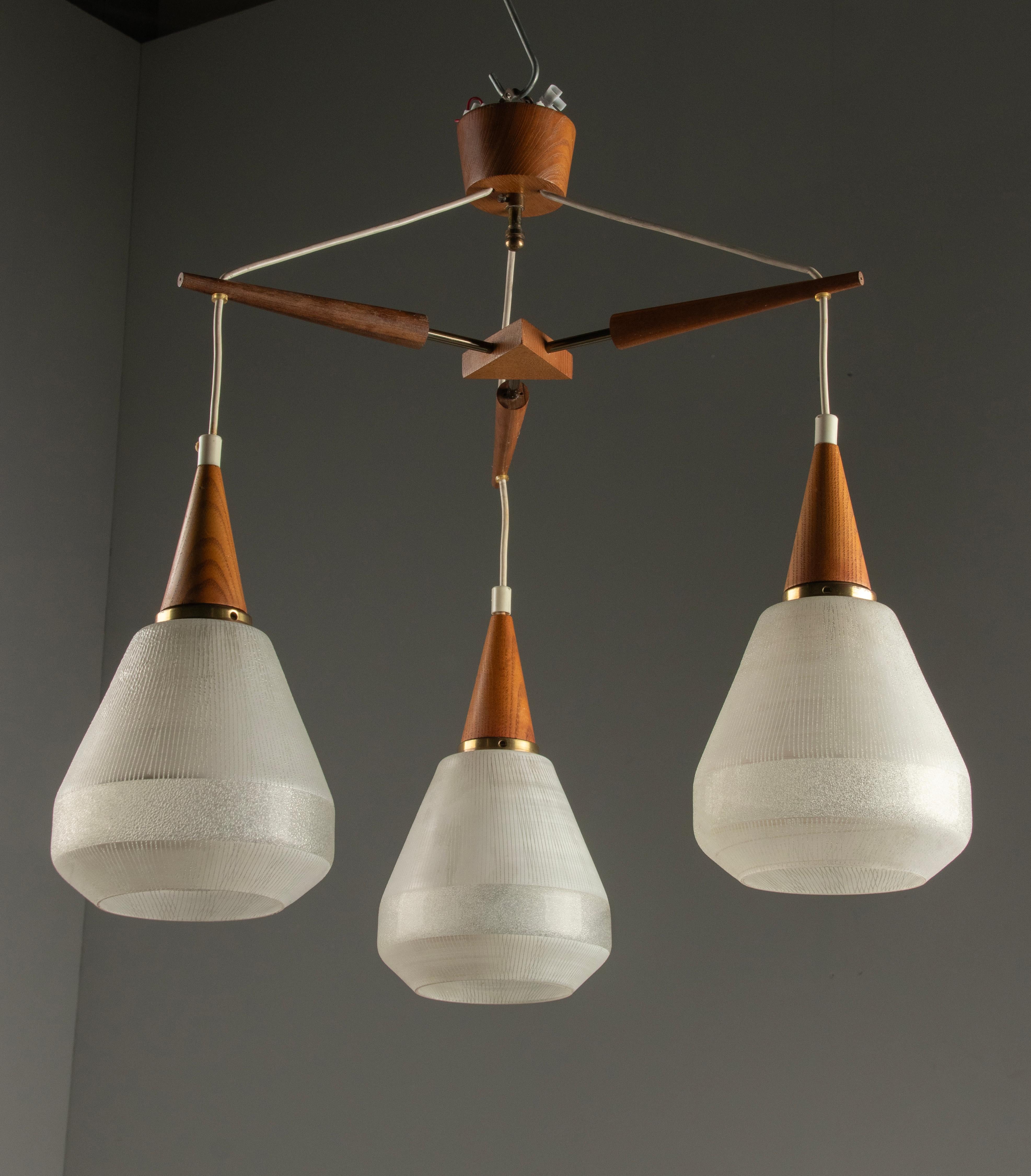 A vintage Danish pendant lamp, made of teakwood with frosted glass lampshades.
Made in Denmark around 1960-1970. Woodwork and glass are in good condition, no chips, hairlines or cracks.

Dimensions: 59 (h) x 56 x 56 cm
Dimension glass shade: Ø 15