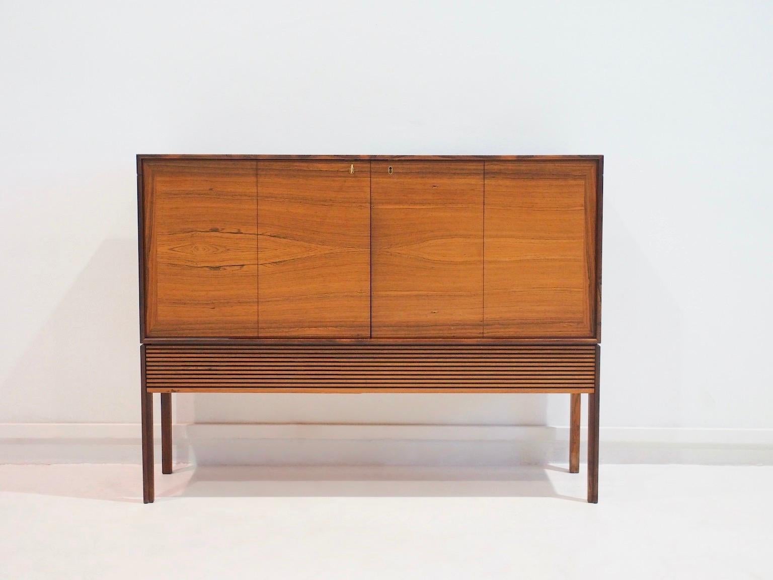 Armoire / console TV en bois fabriquée au Danemark dans les années 1960. Le meuble a deux portes, derrière lesquelles se trouvent des étagères pour cacher un petit téléviseur. Marque 