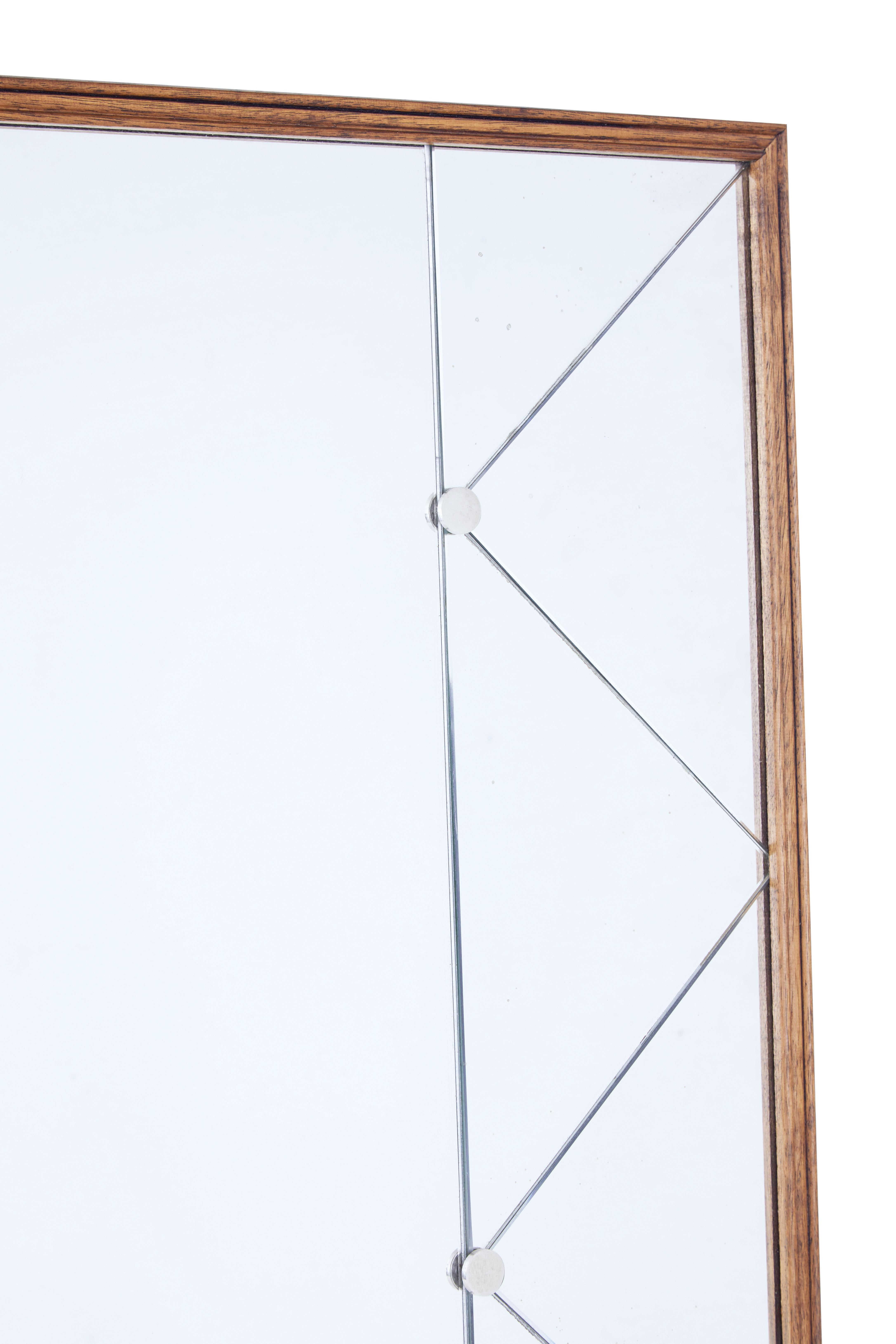 Large and impressive deco inspired mirror, circa 1950.

Thin oak frame, with central mirror flanked either side by diamond and triangle cut mirror.

Mirror segments held in place by steel studs.