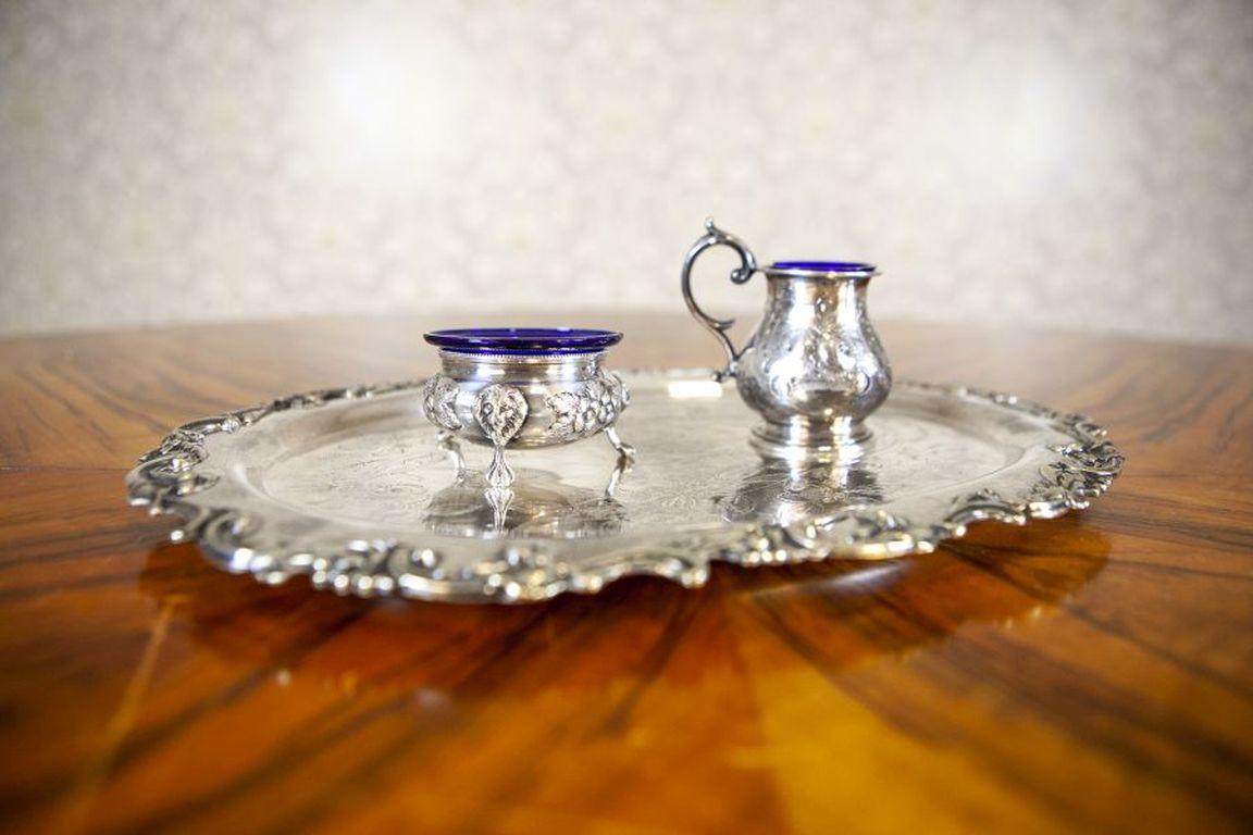 Service de vaisselle décorative en métal argenté avec accents bleus du milieu du 20e siècle

Un ensemble de plats richement décorés avec un plateau, tous les éléments sont plaqués argent (poinçons estompés). L'une des entrées de verre bleu est