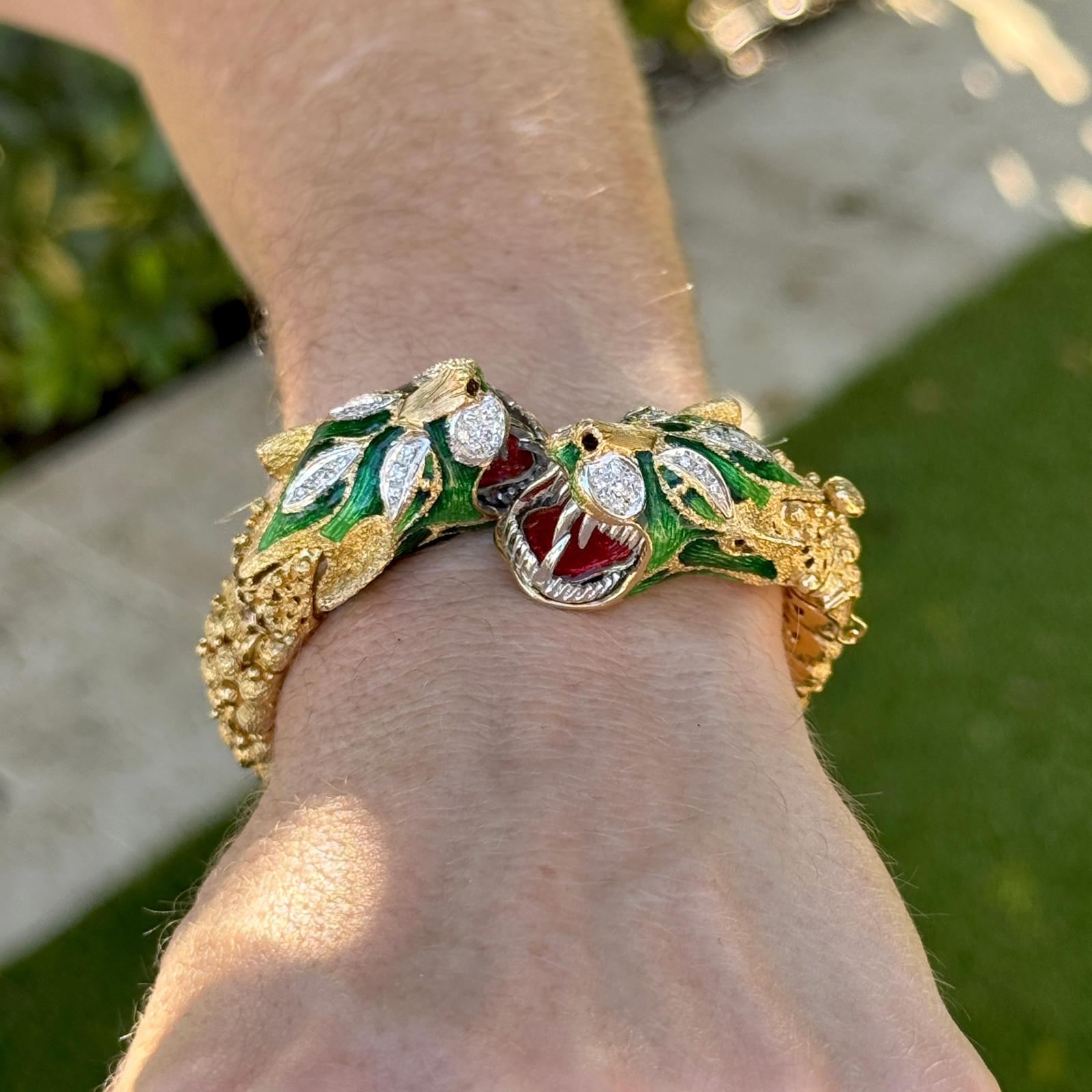 Questo straordinario braccialetto flessibile mostra due teste di drago intricate e dettagliate in oro giallo 18 carati, ornate da un ricco smalto verde e da scintillanti accenti di diamanti per un totale di circa 0,50 carati. Il design misura circa