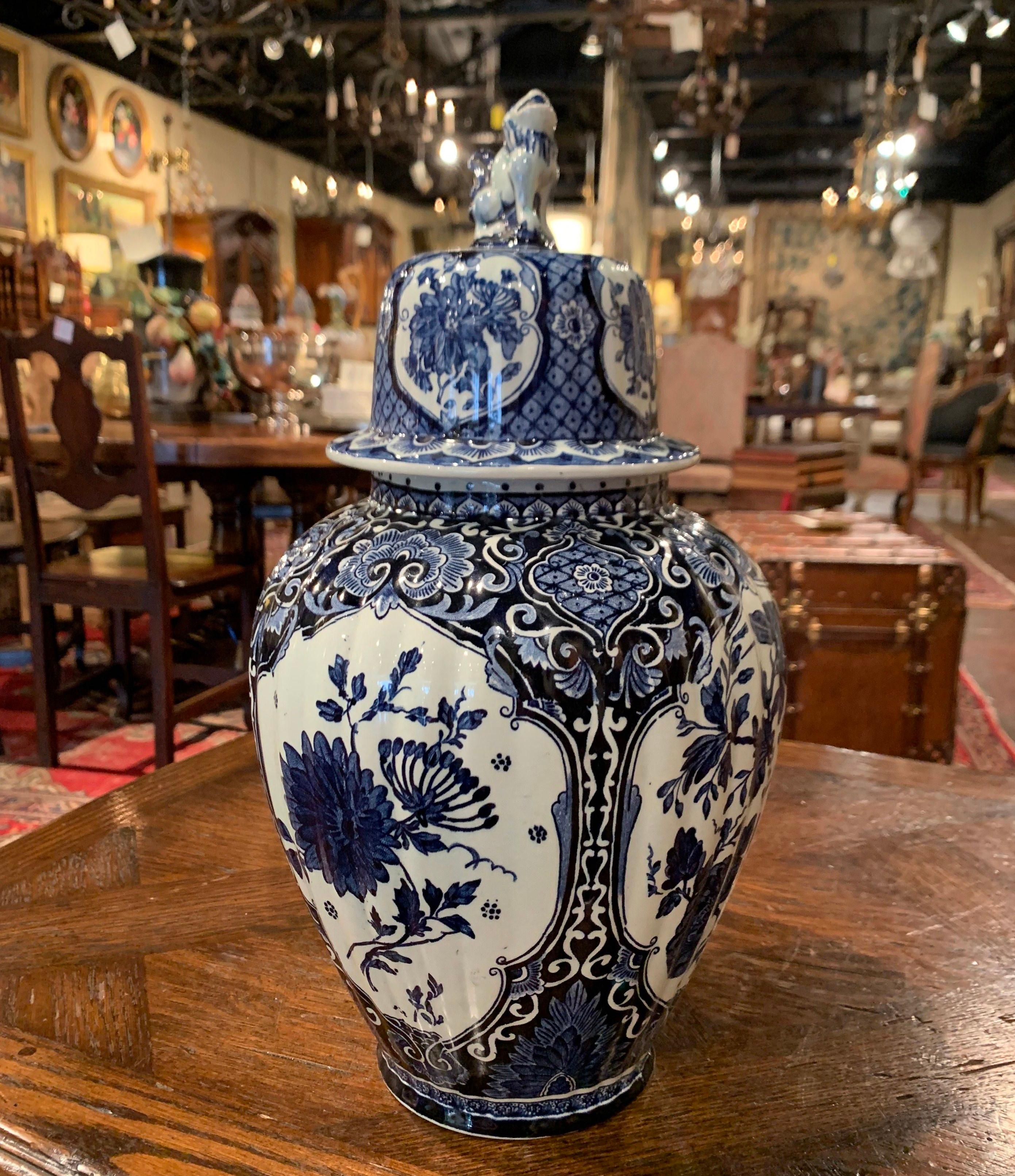 Created in Holland, circa 1960, the faience potiche features hand painted medallions with Classic Dutch flowers and foliage motifs. Stamped Delfts on the bottom with 